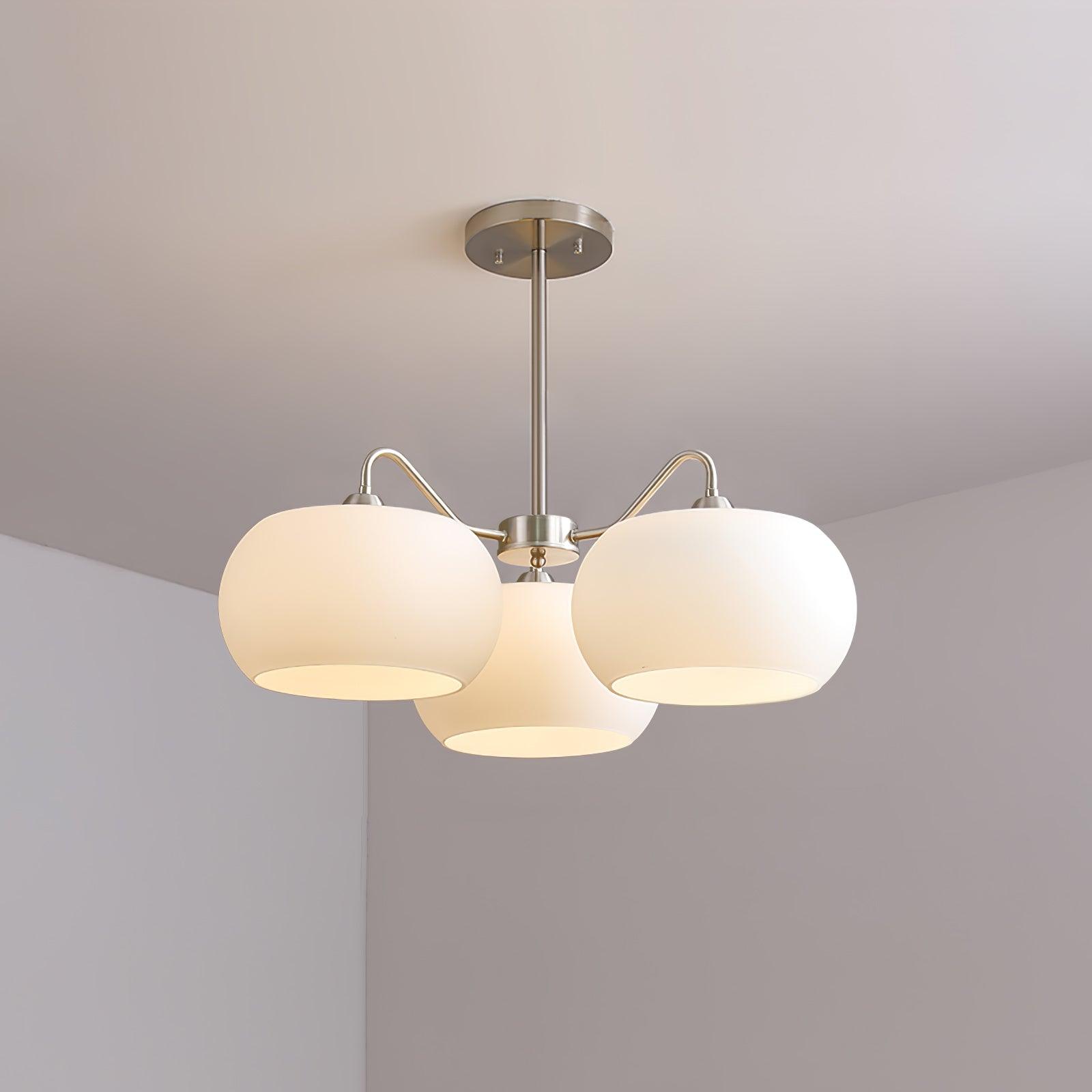 Three-light white glass chandelier with curved nickel-tone arms, a straight rod and round ceiling canopy