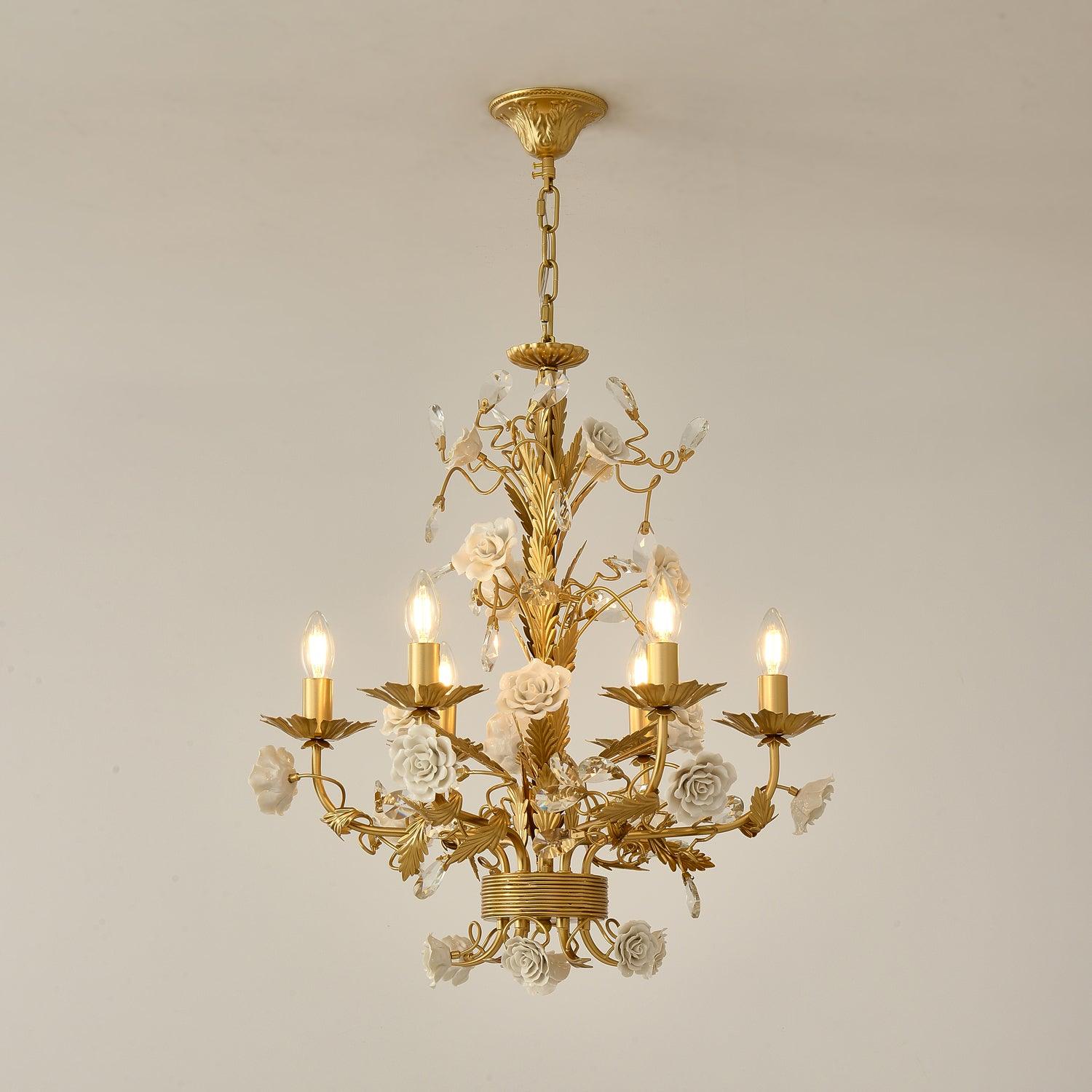 Six-light White Rose chandelier lit against beige, with gold-tone canopy and chain, white roses and clear crystal buds