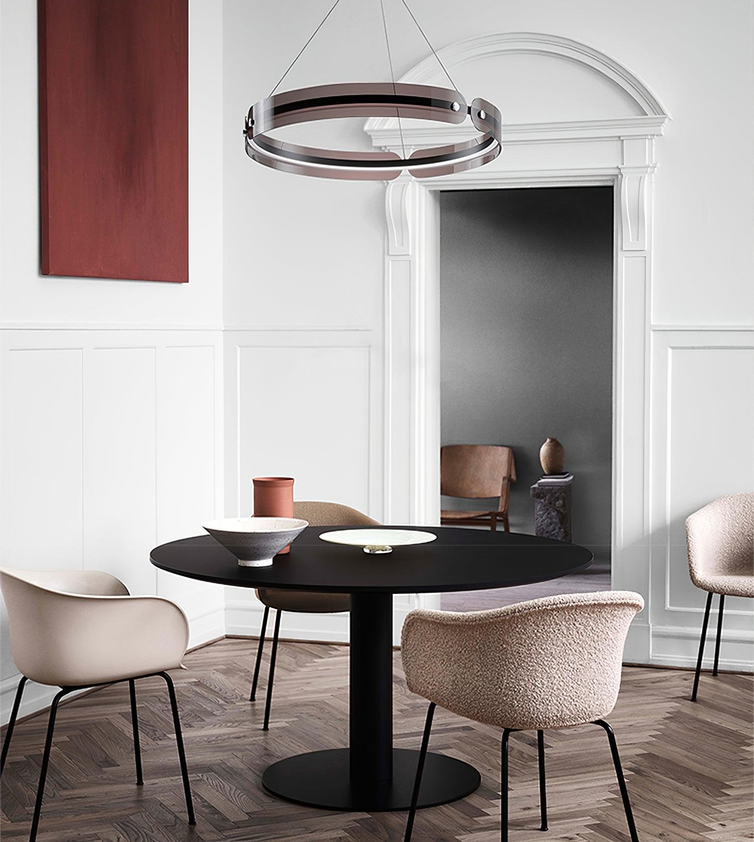 Javor black and coffee ring above a round black dining table with cream chairs, bowls and red wall art
