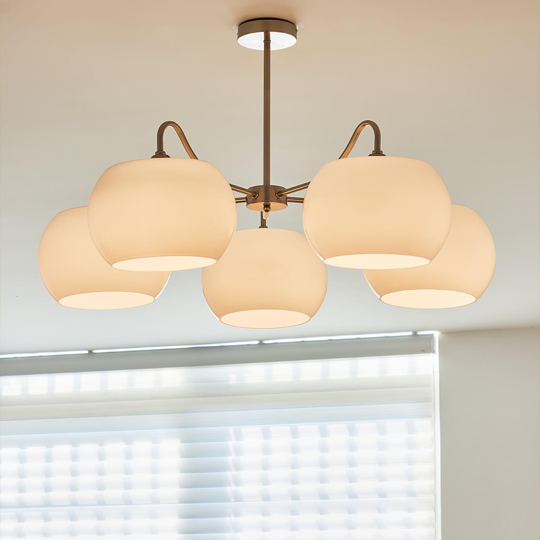 Persimmon chandelier with white glass shades and curved nickel-tone arms