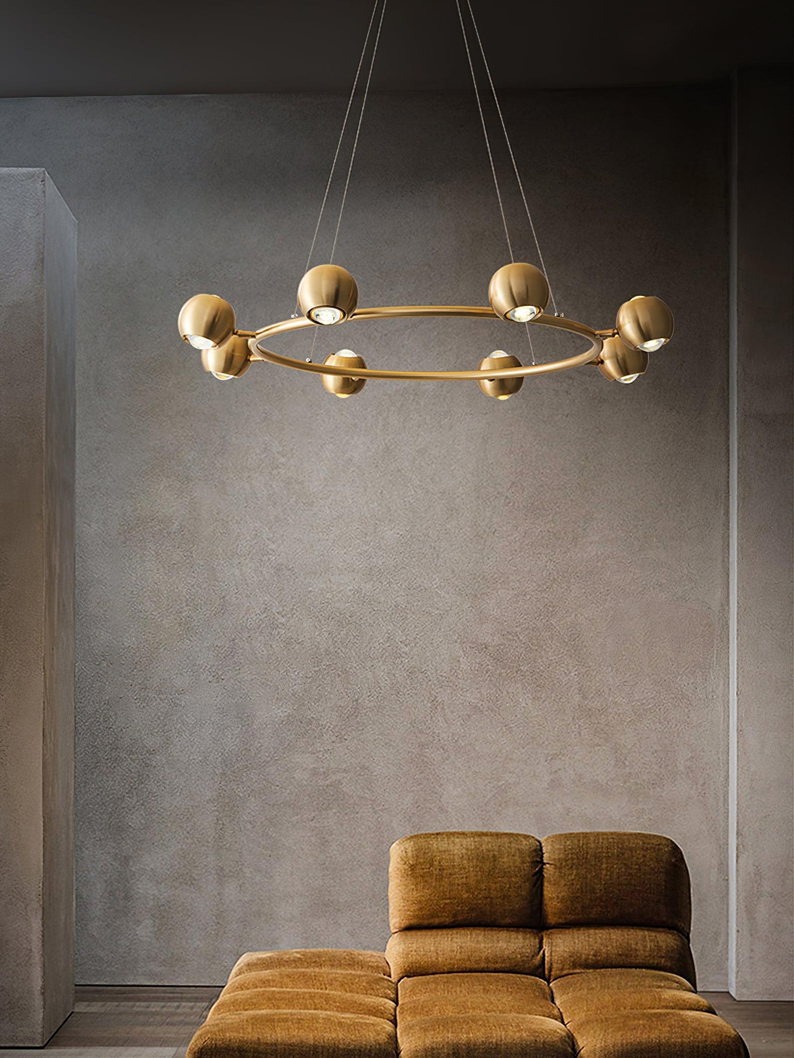 Brass ring chandelier above a mustard-coloured armchair