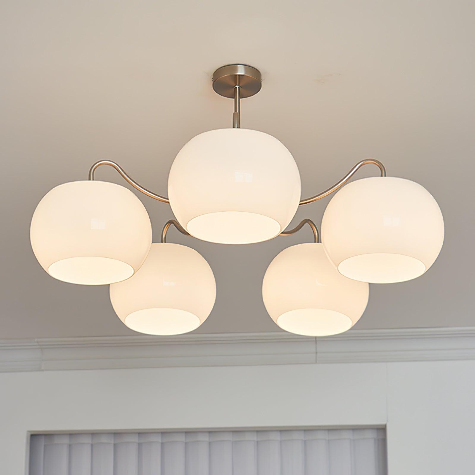 Persimmon chandelier with white glass shades and curved nickel-tone arms