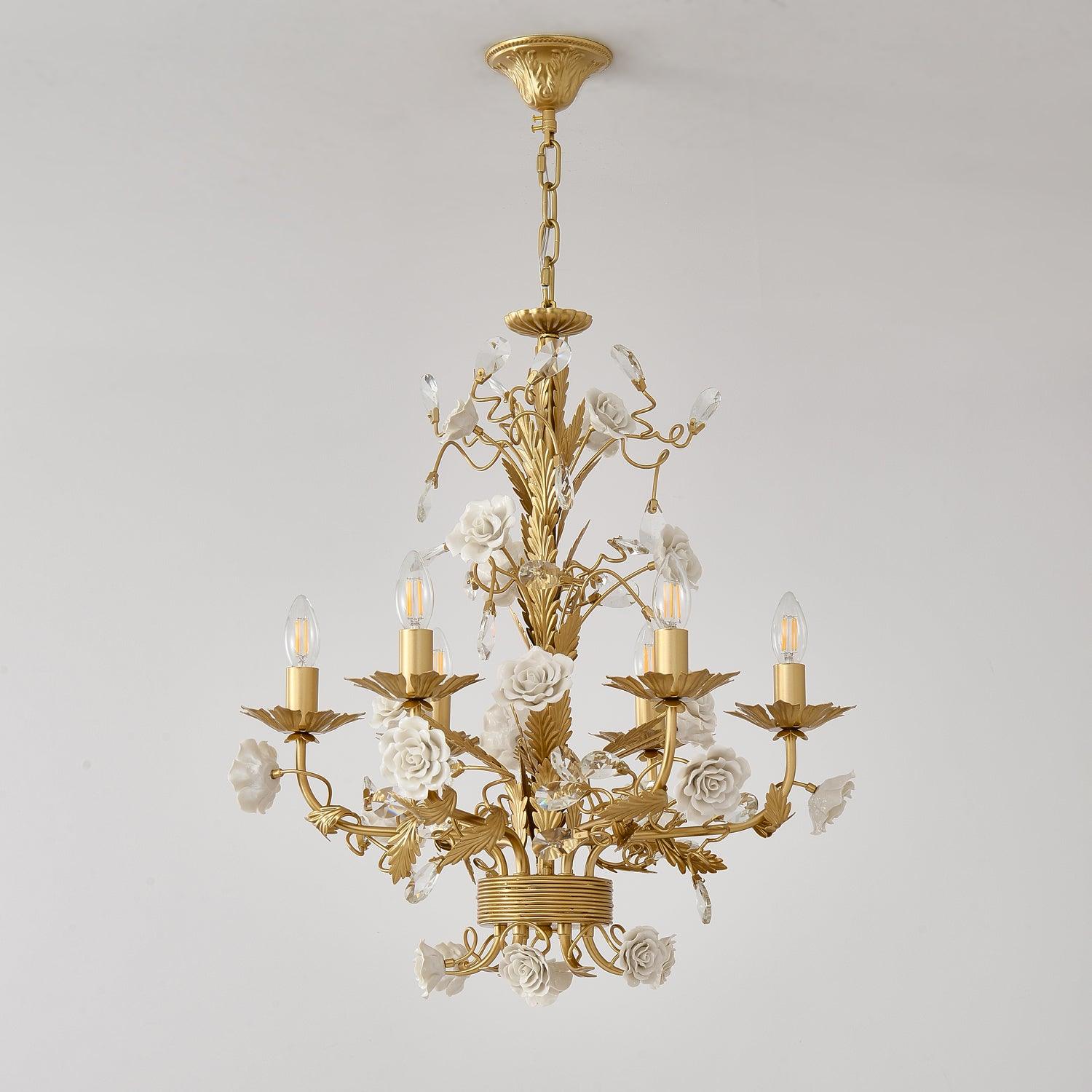Full unlit White Rose chandelier against pale gray, showing embossed gold-tone canopy, chain, ceramic roses and crystal buds