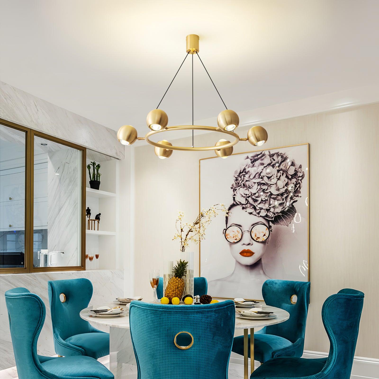 Brass ring chandelier above a table with turquoise chairs