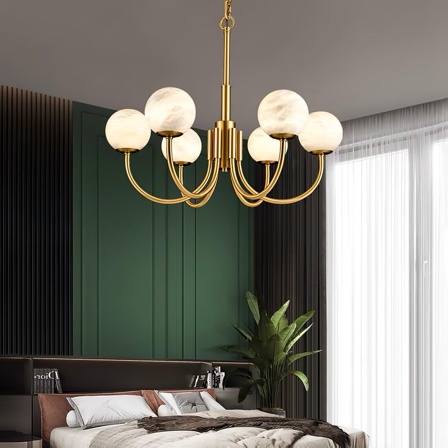 Brass globe chandelier in bedroom with dark green wall