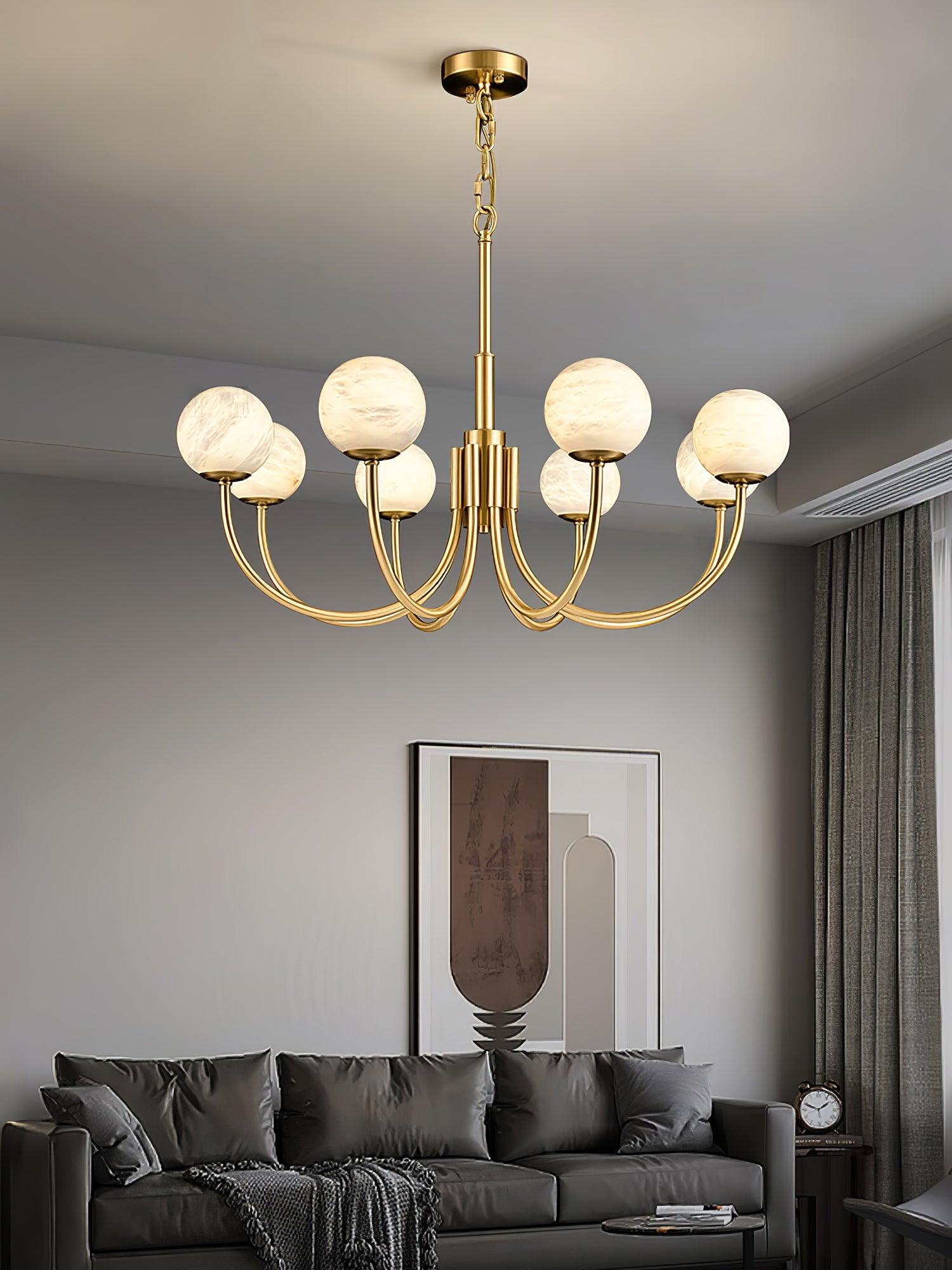 Brass globe chandelier over sofa and wall art