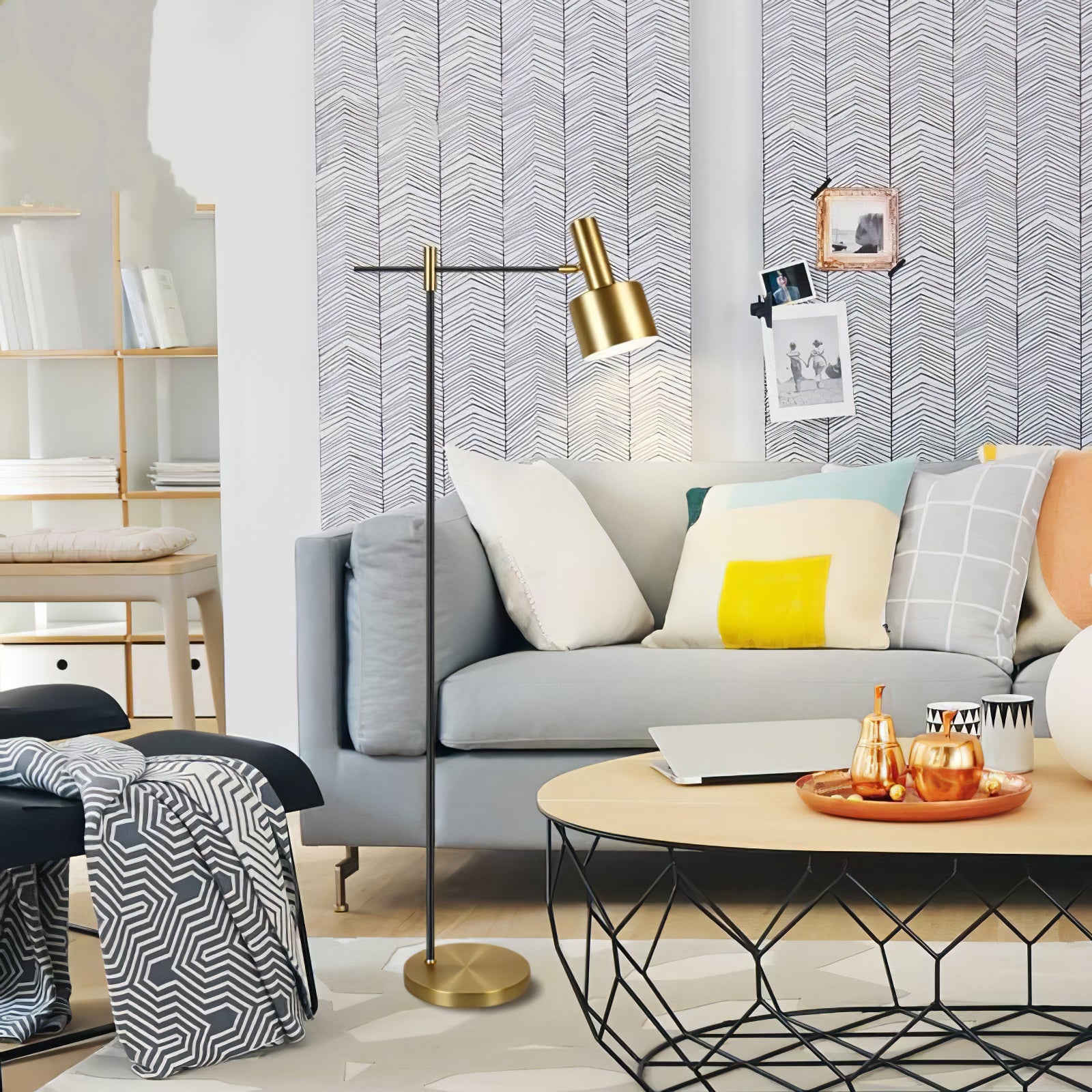 Gold-headed floor lamp beside grey sofa and coffee table with laptop, gold tray and colourful cushions