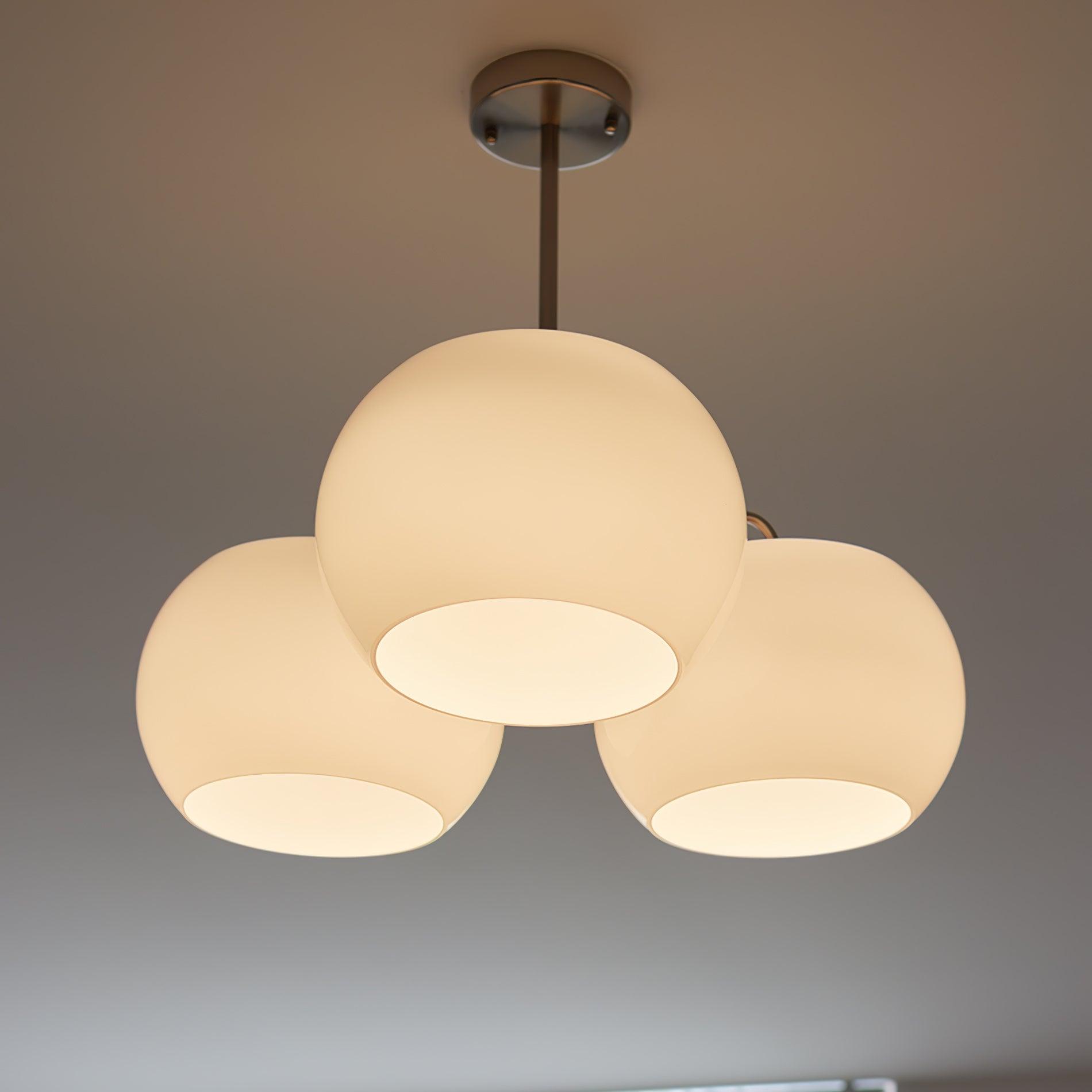 Persimmon chandelier with white glass shades and curved nickel-tone arms