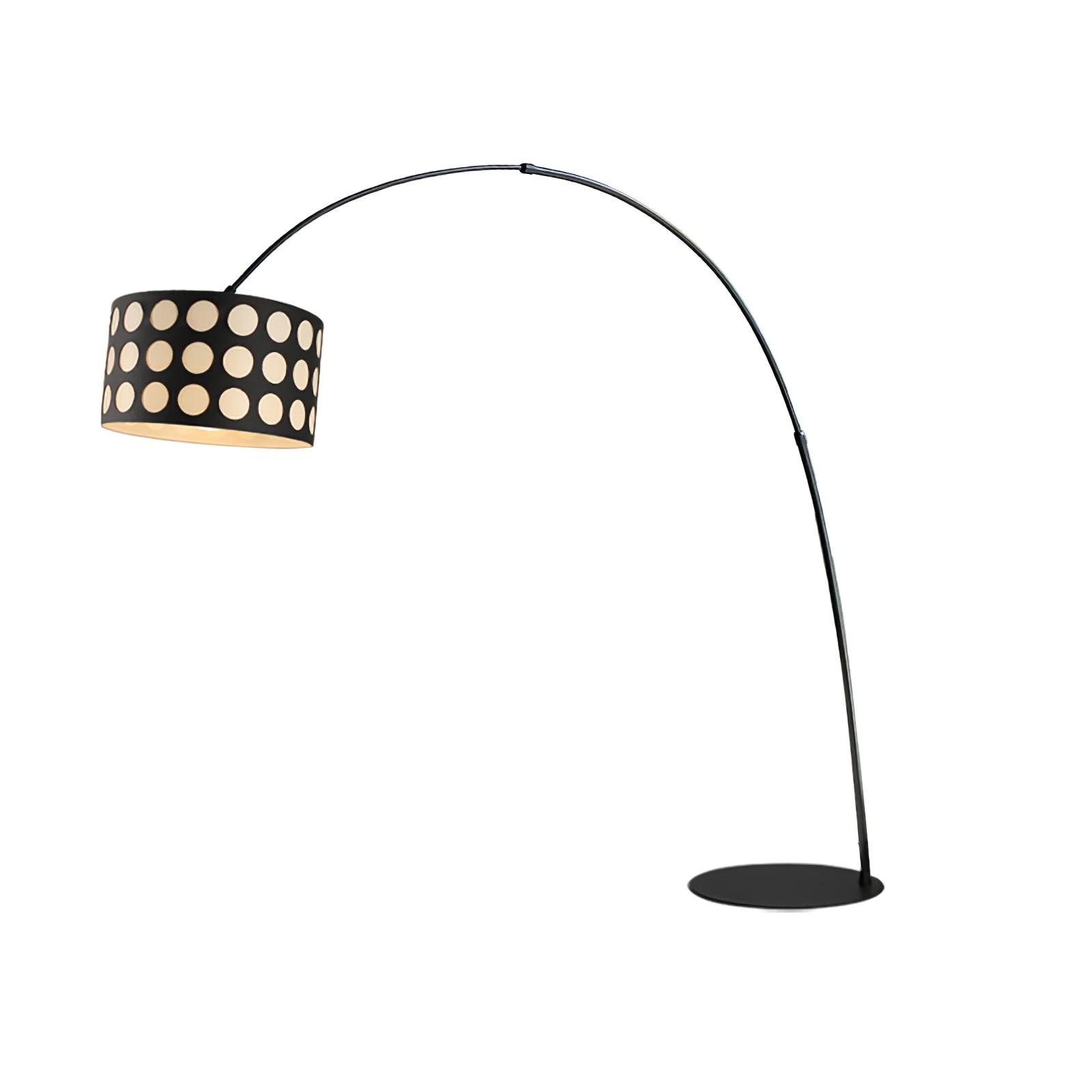 Isolated black arc floor lamp with pale dotted drum shade on left, curved stem and circular base on right