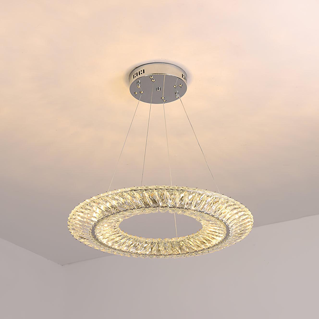 Single crystal ring chandelier suspended on thin wires below a round silver-coloured canopy