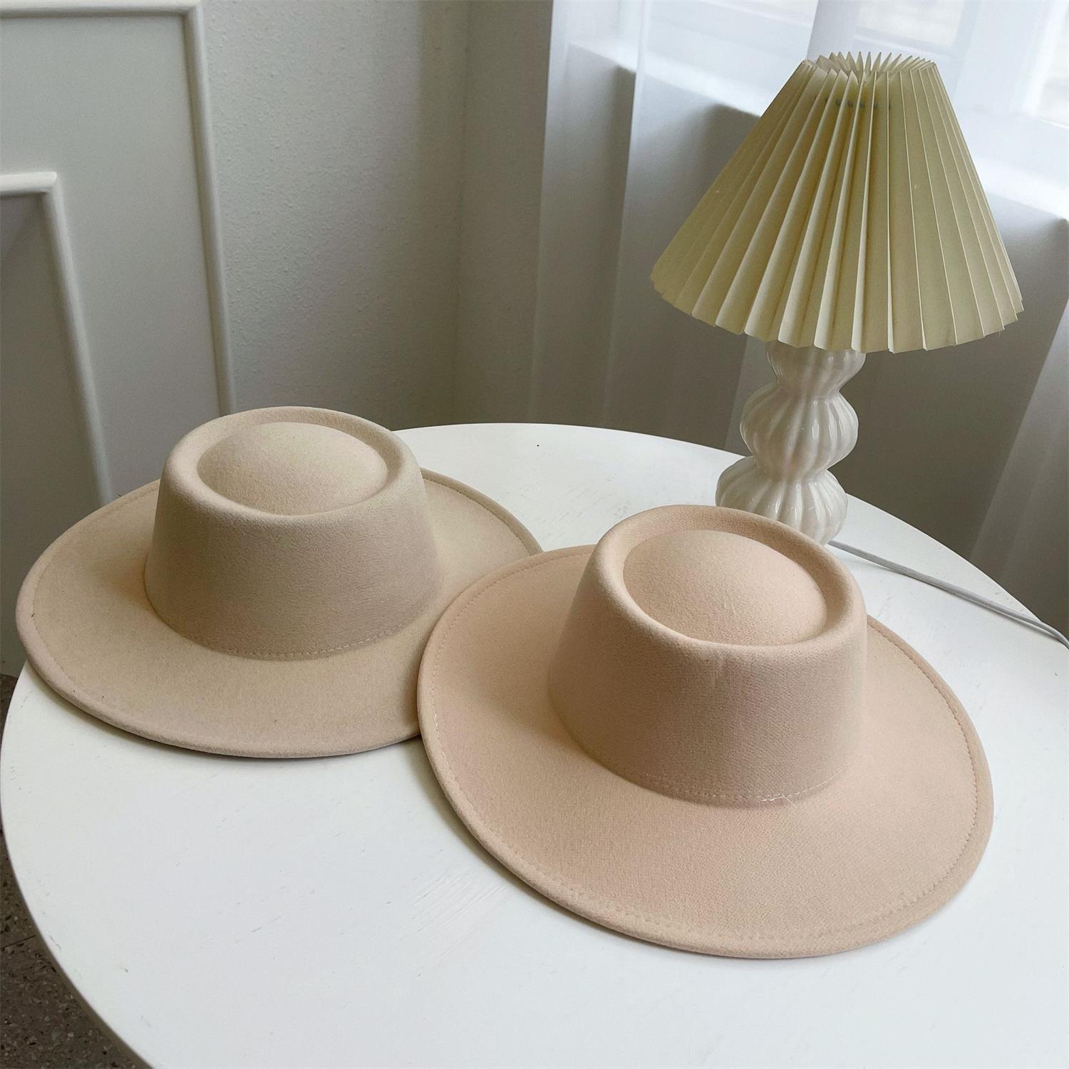 Leo lamp beside beige hats on a round table