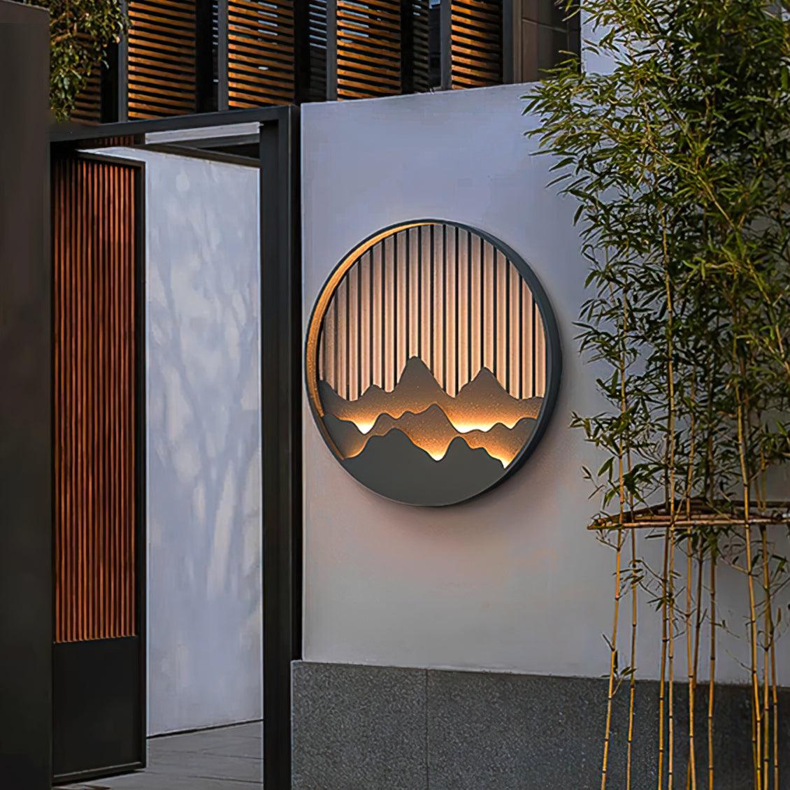 Mountain landscape light on white courtyard wall beside open wooden slat gate and bamboo stems