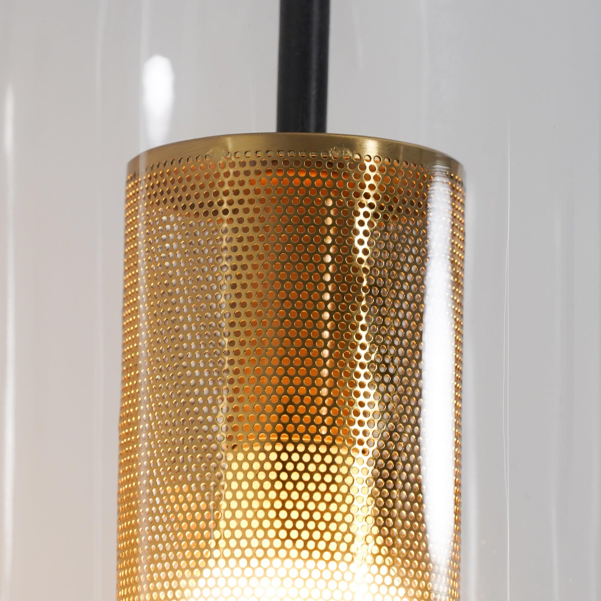 Macro detail of the upper rim and circular holes in Vadim gold-coloured inner cylinder, black rod behind glass