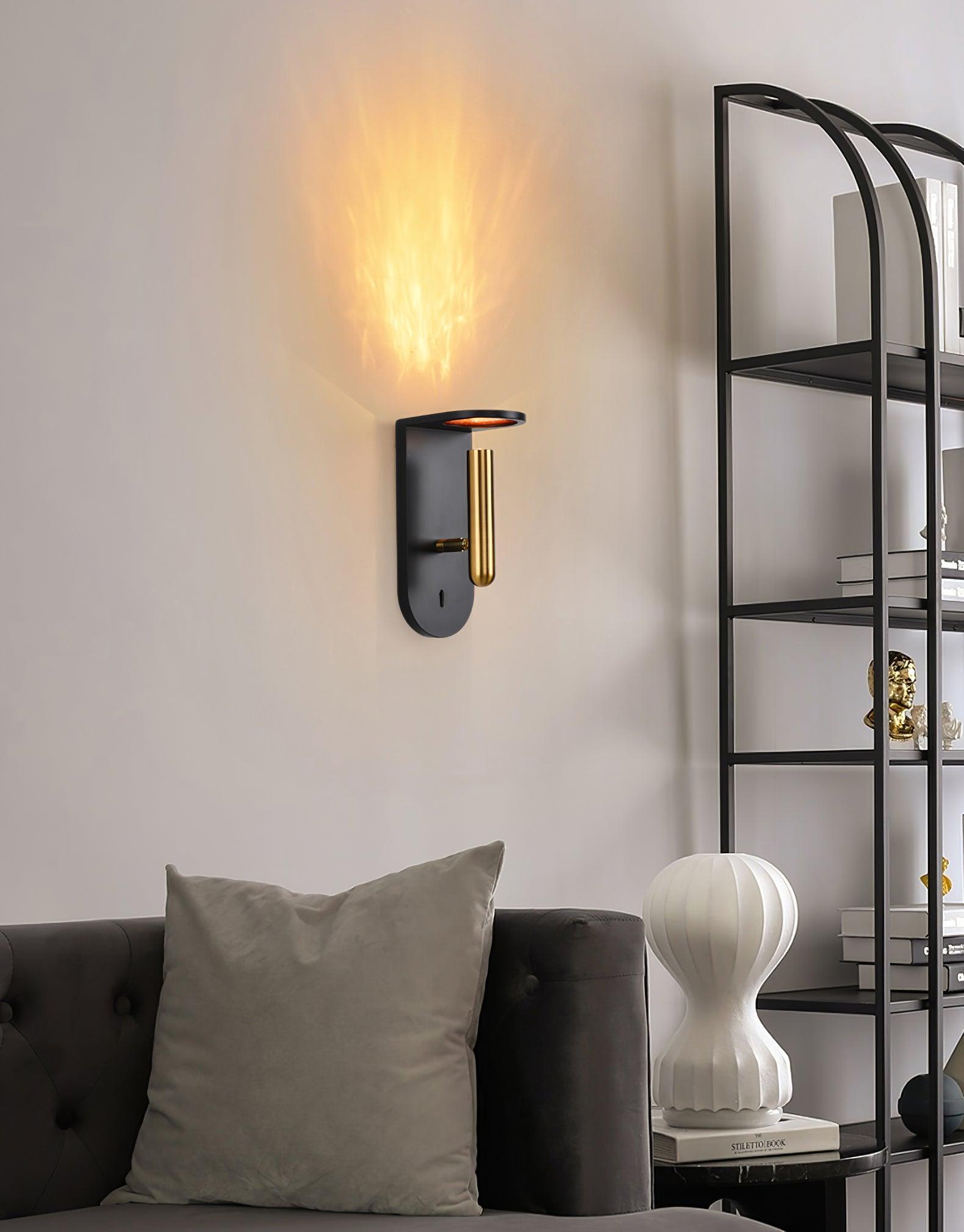 Black Nights wall light casting an upward glow above a sofa beside shelving