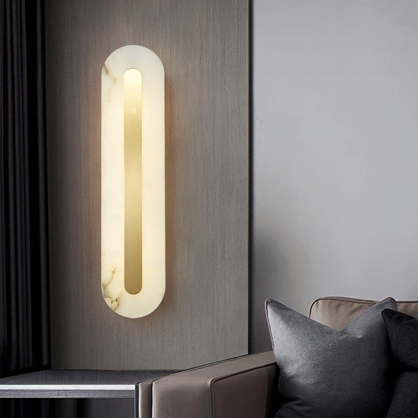 Glowing rounded alabaster wall light beside an armchair and dark side table