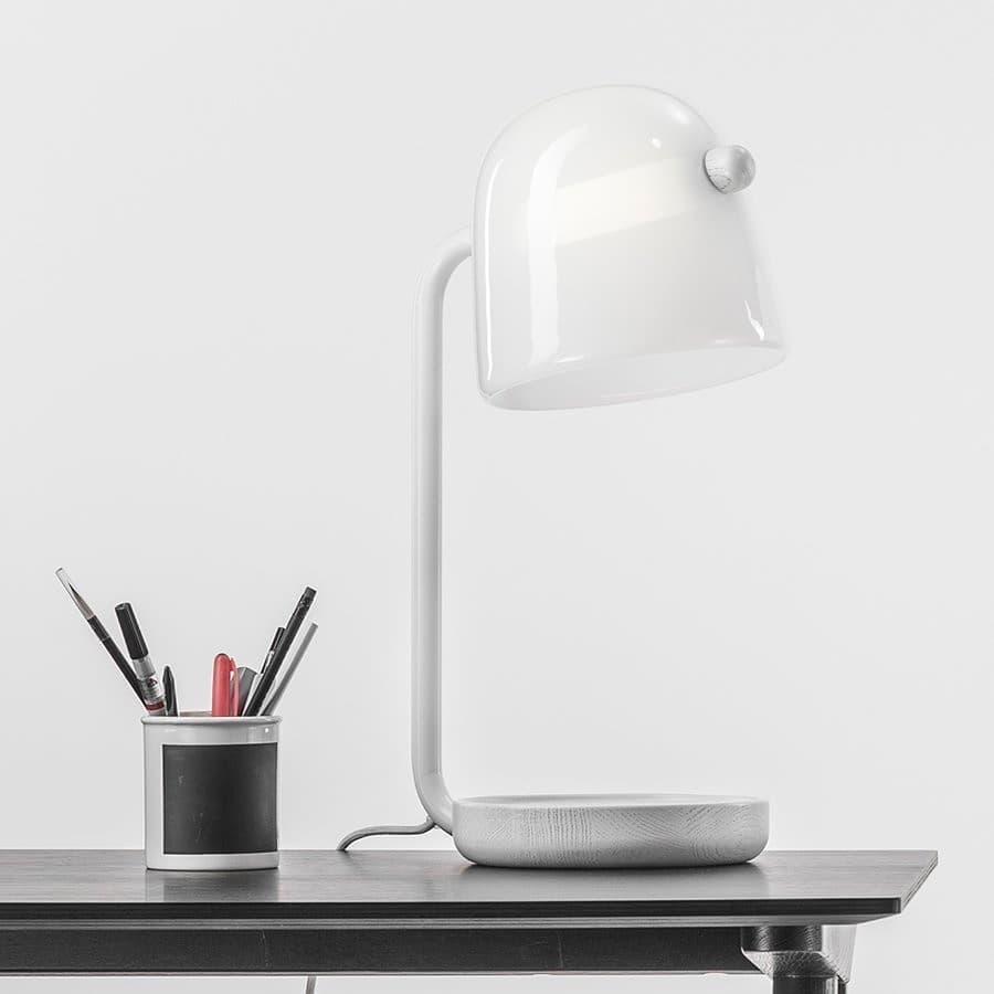 White Mona lamp on a desk beside a pen cup