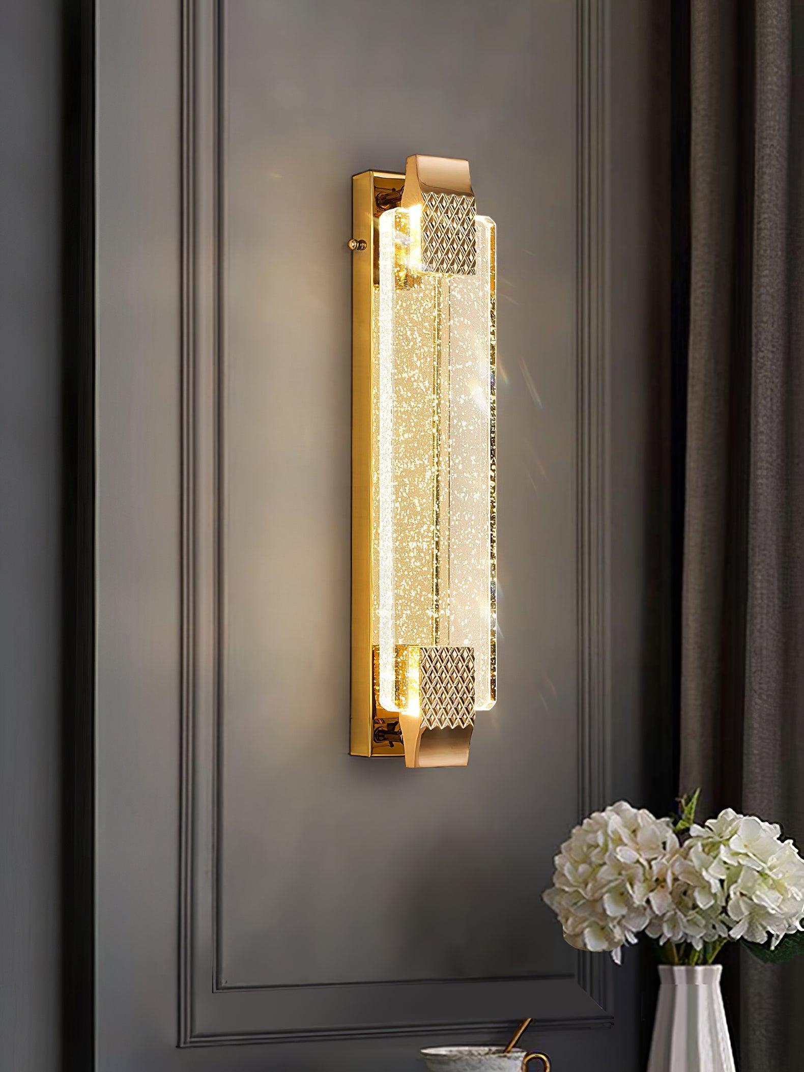 Moet sconce glowing on gray wall molding above a table with white hydrangeas and a bowl