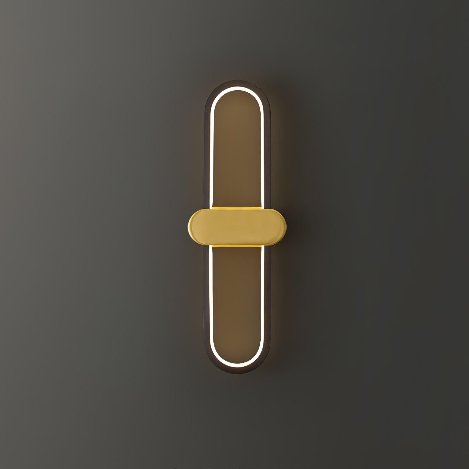 Close view of a lit black oval loop and gold-coloured horizontal centre on a grey background