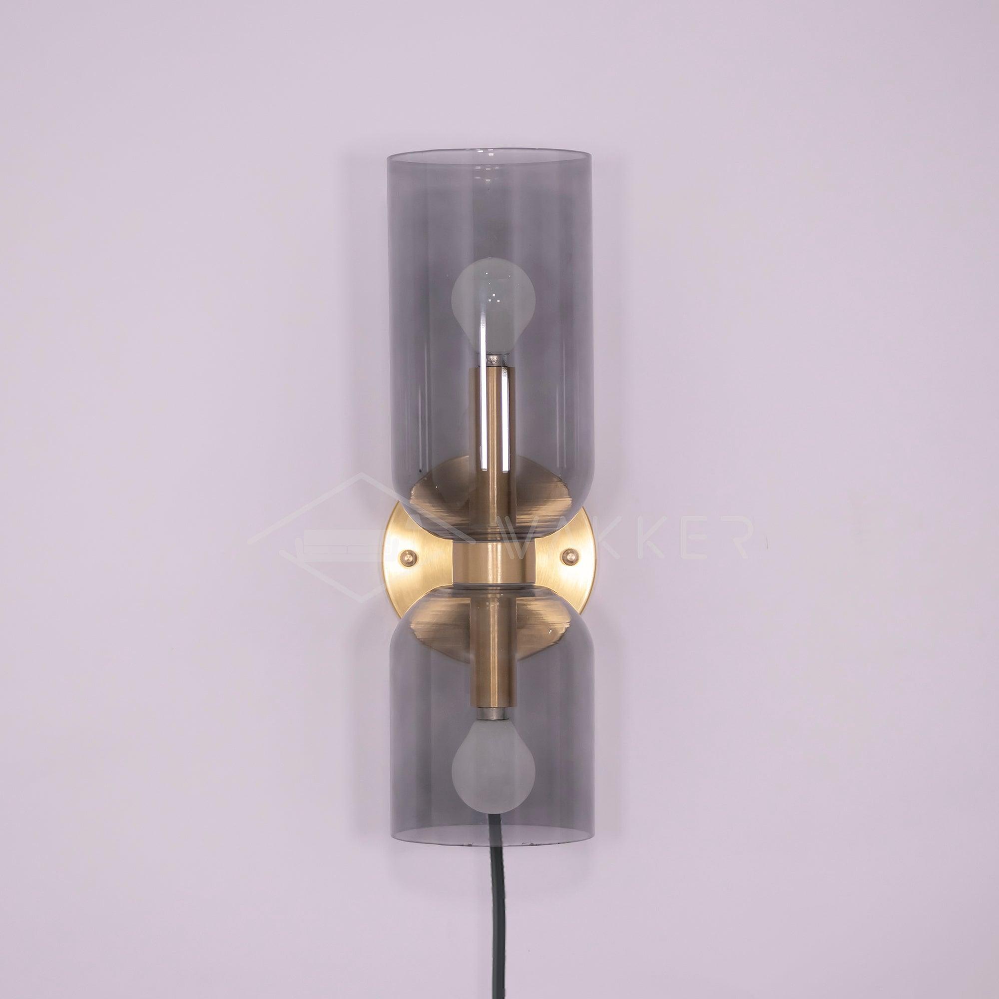 Satin Brass wall plate between unequal Smoked Gray cylinders