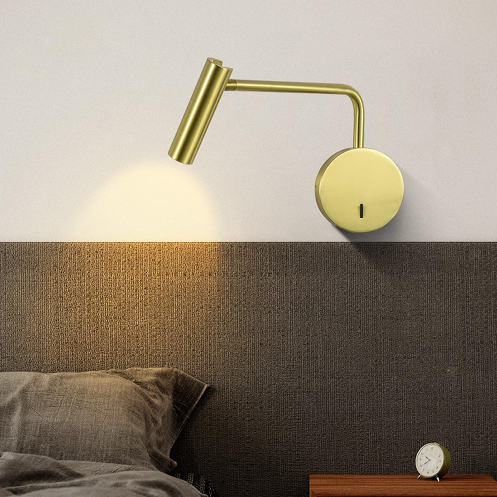 Gold-coloured adjustable light above a headboard