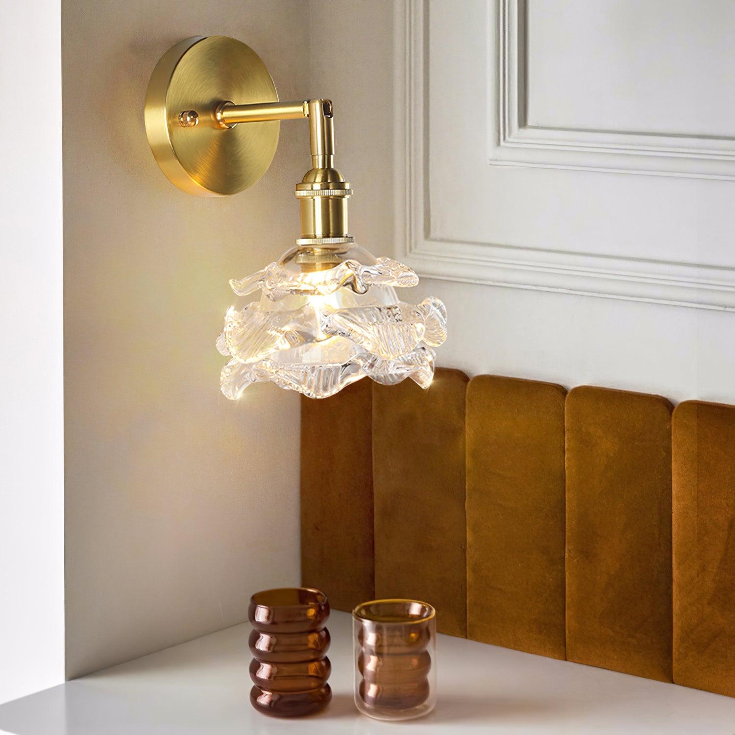 Clear flower wall lamp above a bedside cabinet