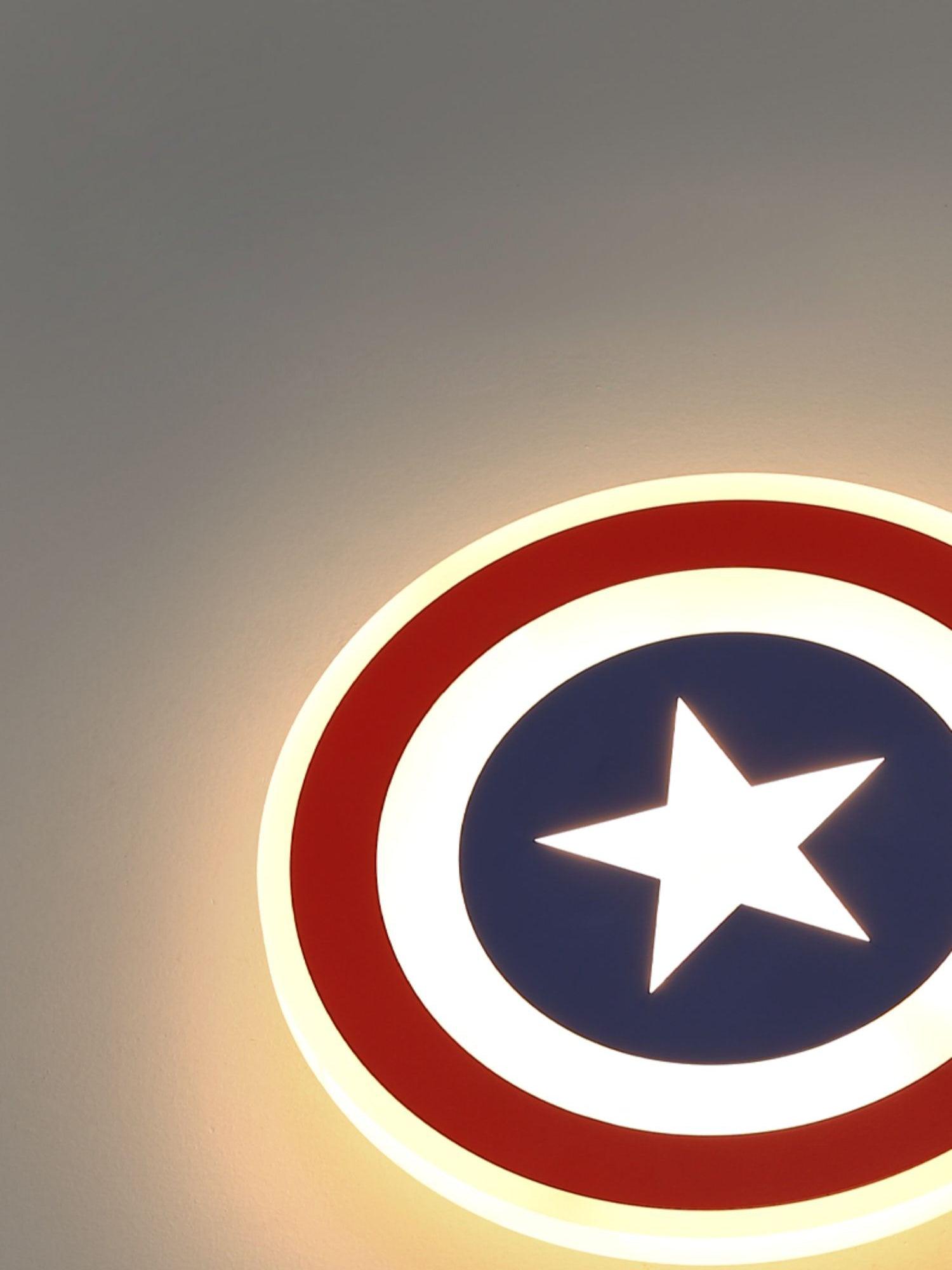Cropped lit red outer ring and blue centre with bright white star, angled against grey wall