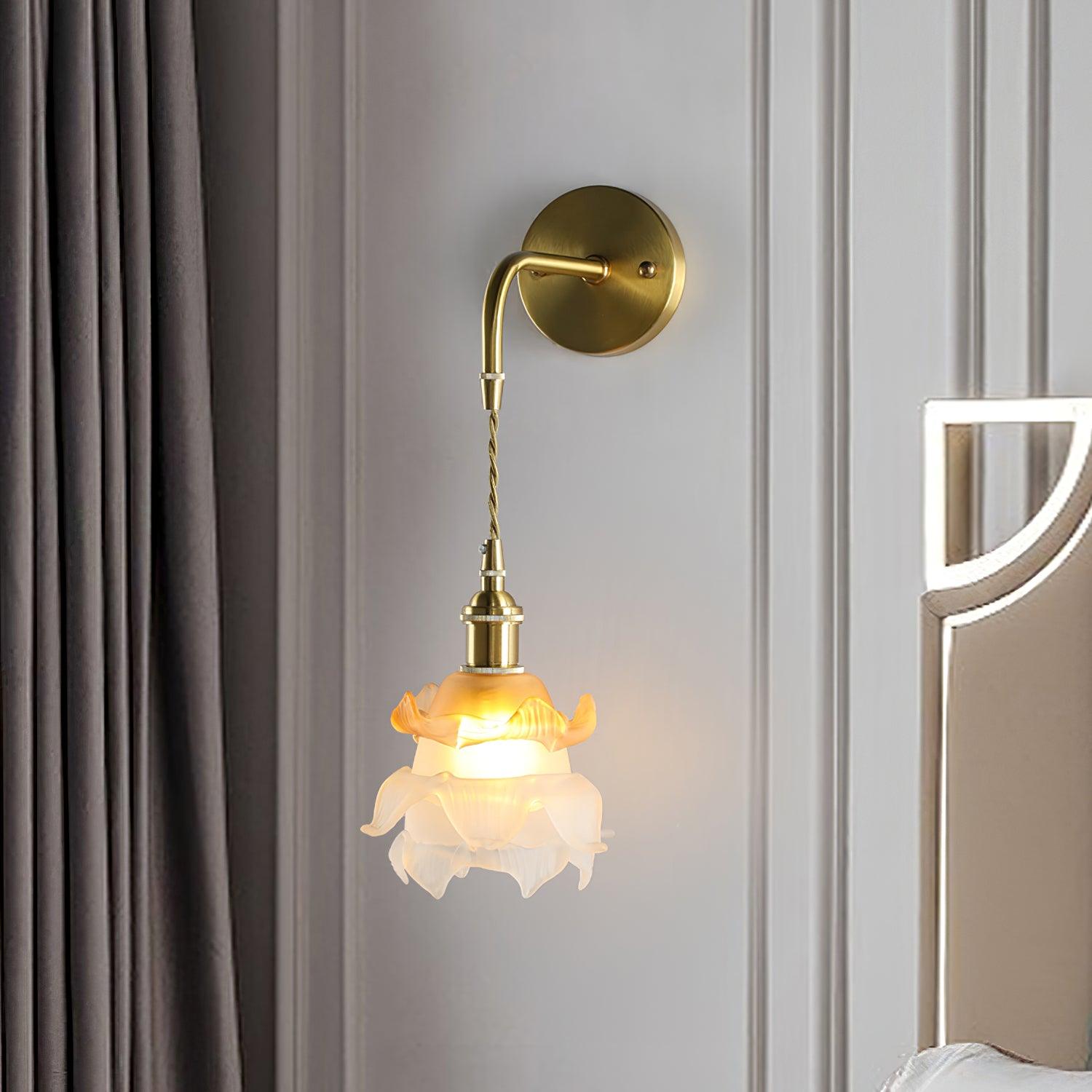 Laura brass floral wall light beside pale curtains