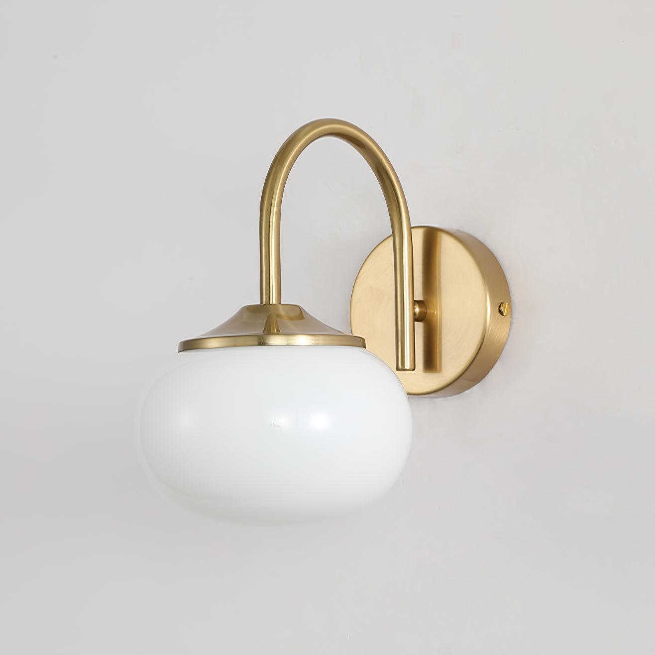Unlit White glass shade below a curved gold-coloured arm