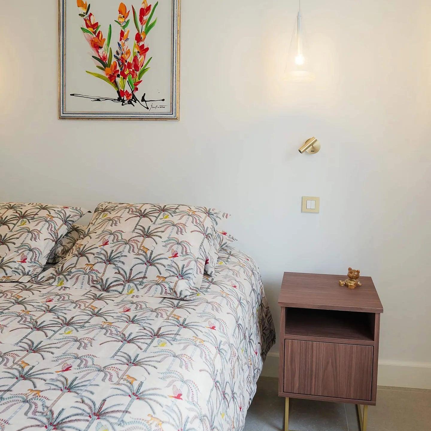 Reading light beside floral bedding