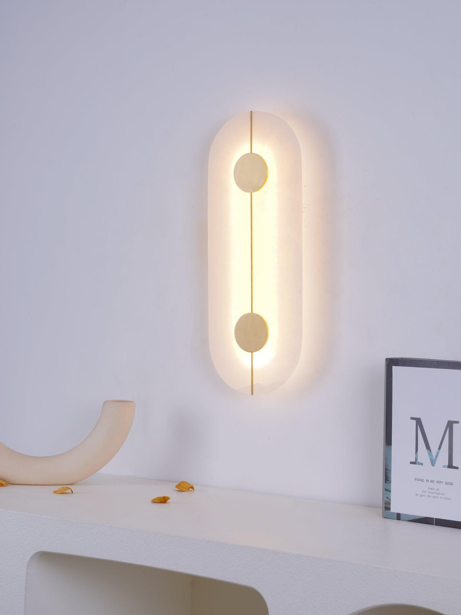 Illuminated capsule wall light above a console