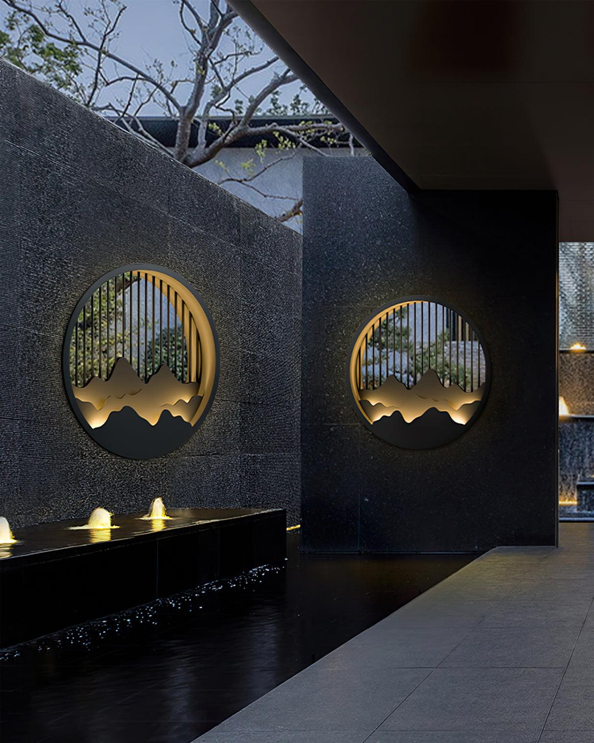 Two mountain wall lights on adjoining dark courtyard walls above a separate water feature with small illuminated jets