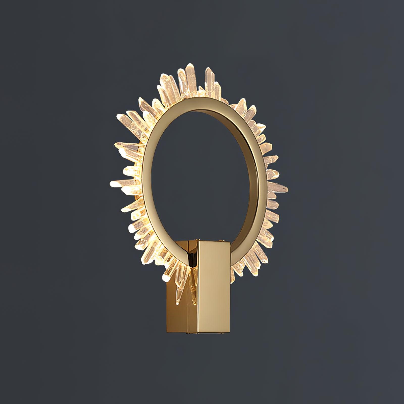 Isolated angled gold ring wall light with a glowing clear crystal rim on a dark grey background