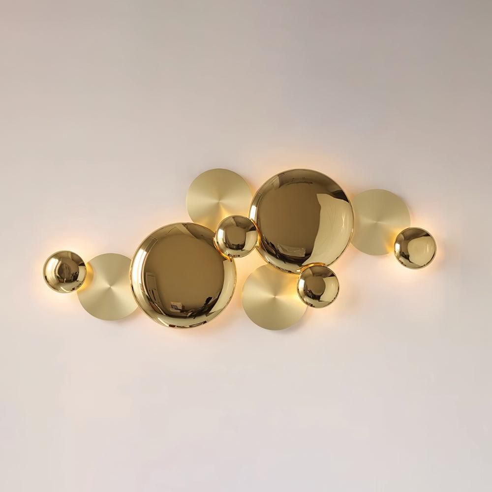 Pale-background front view of the illuminated Gold Pisco lamp and its overlapping circular composition