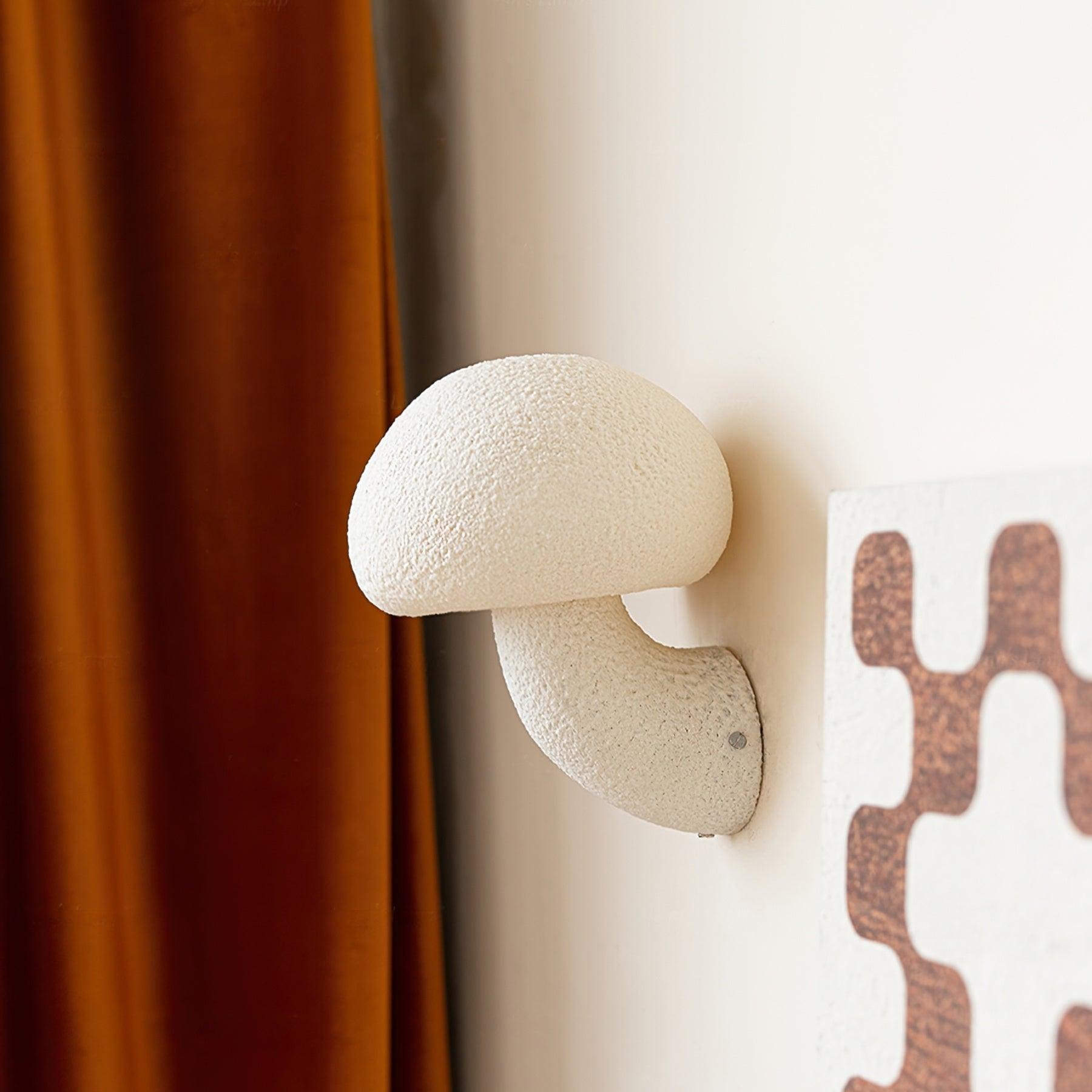 White mushroom cap and curved stalk beside wall art