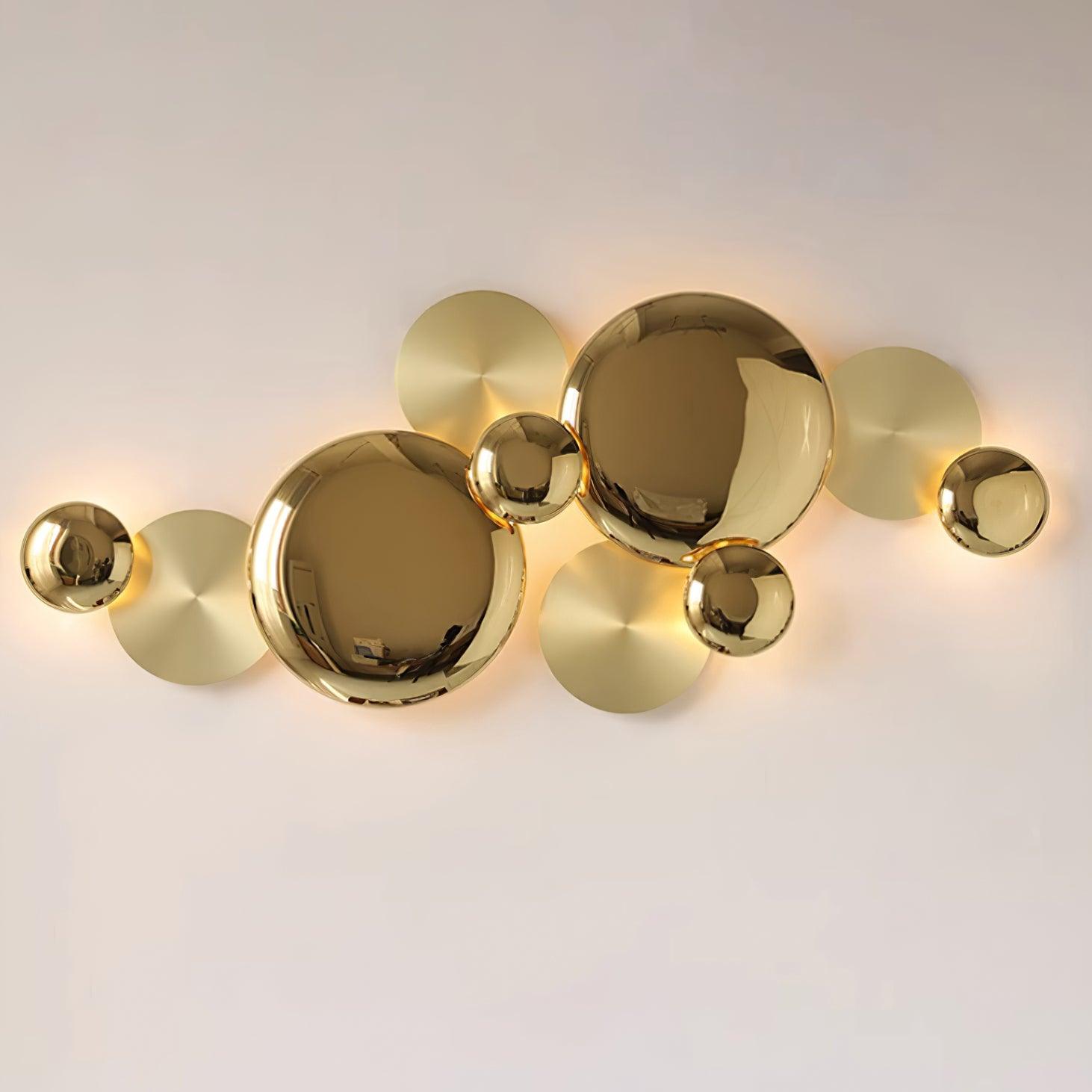 Close front view of polished and brushed-looking gold-tone discs with light around their edges