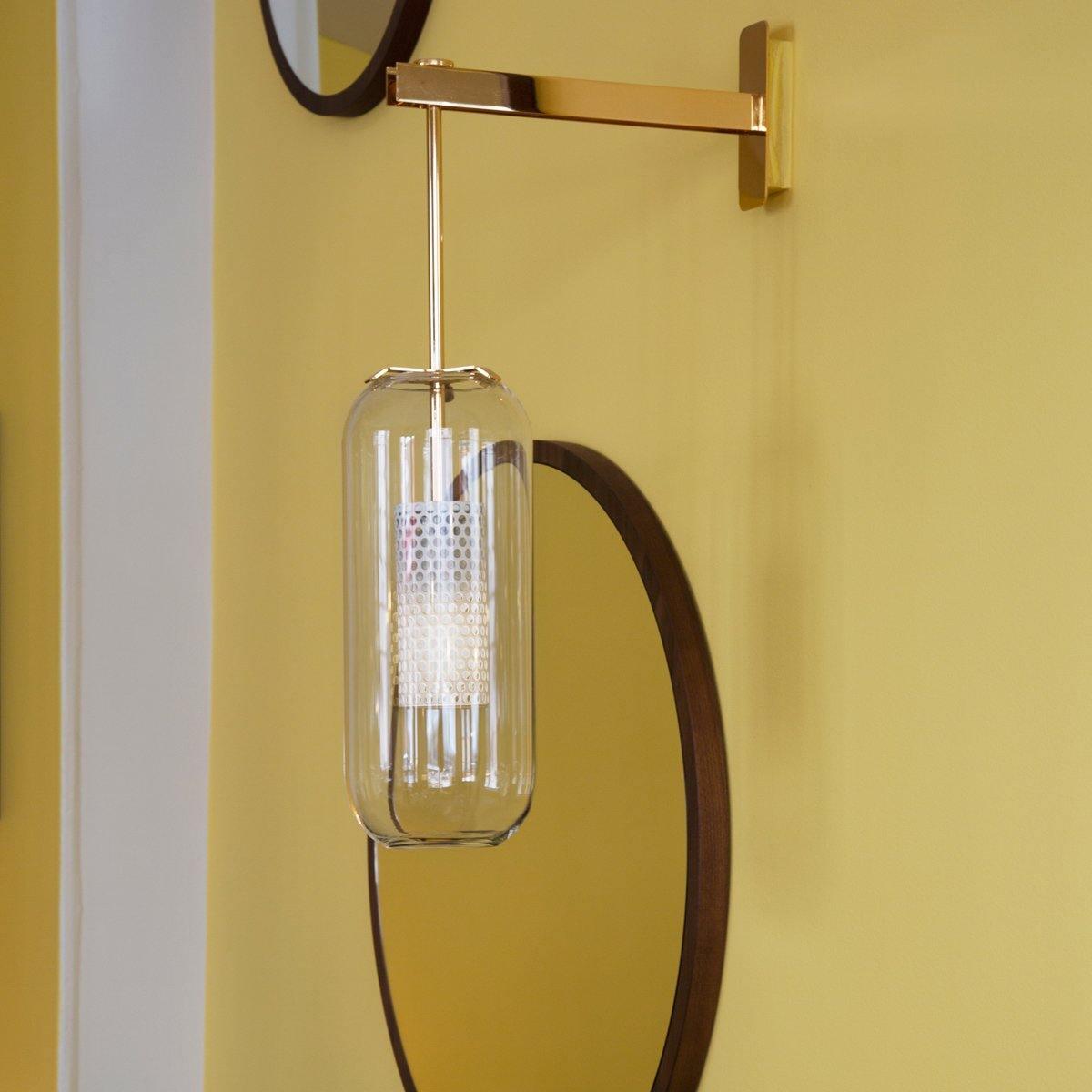 Clear glass shade beside an oval mirror