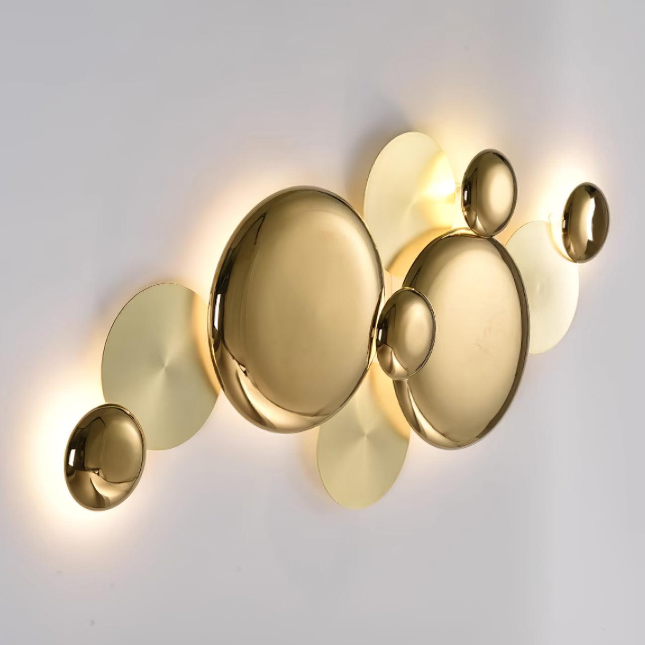 Oblique side view of the gold Pisco lamp showing raised dish-like faces and overlapping flatter discs