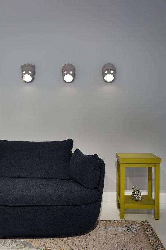 Three face wall lights above a sofa and yellow table