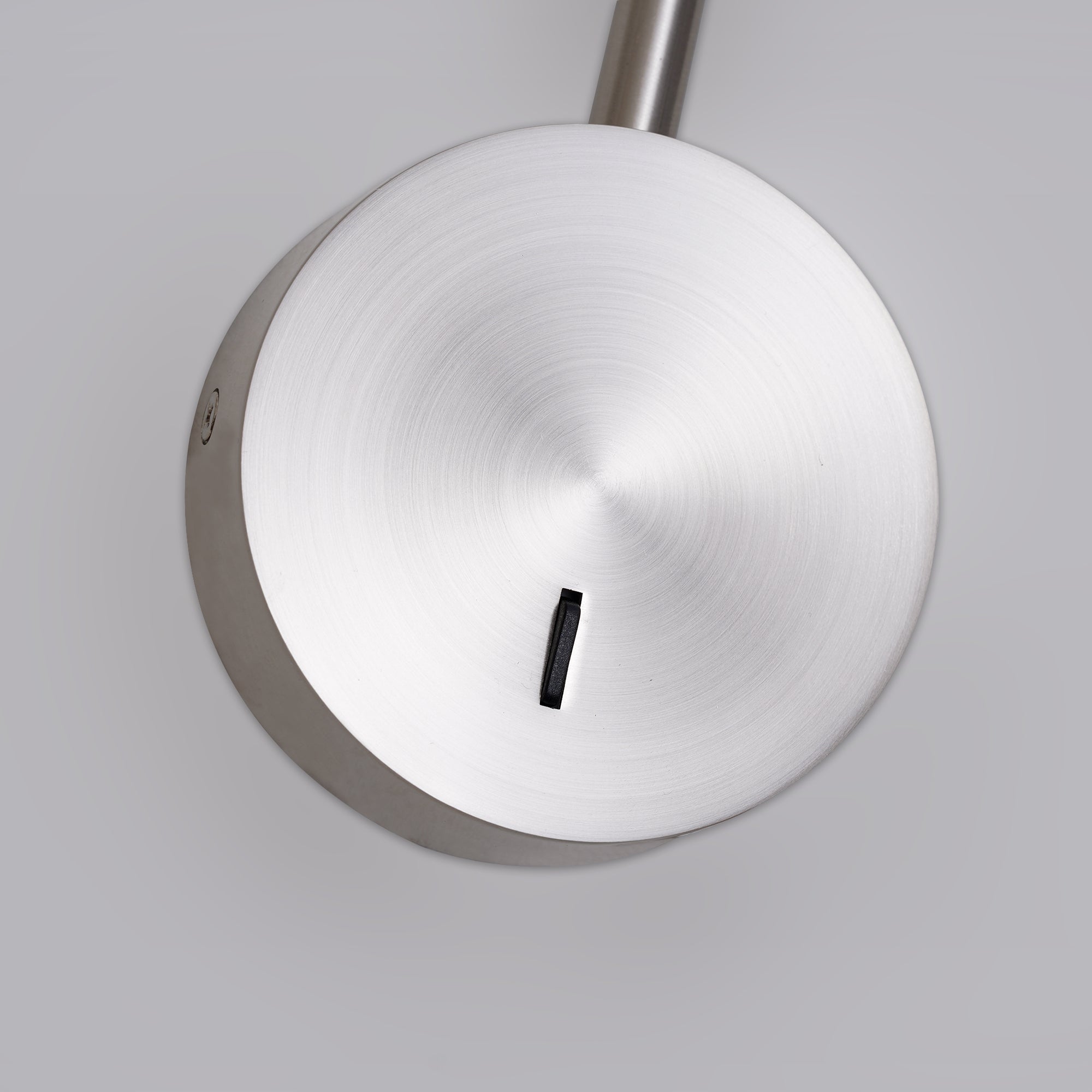 Round brushed plate with a small black control