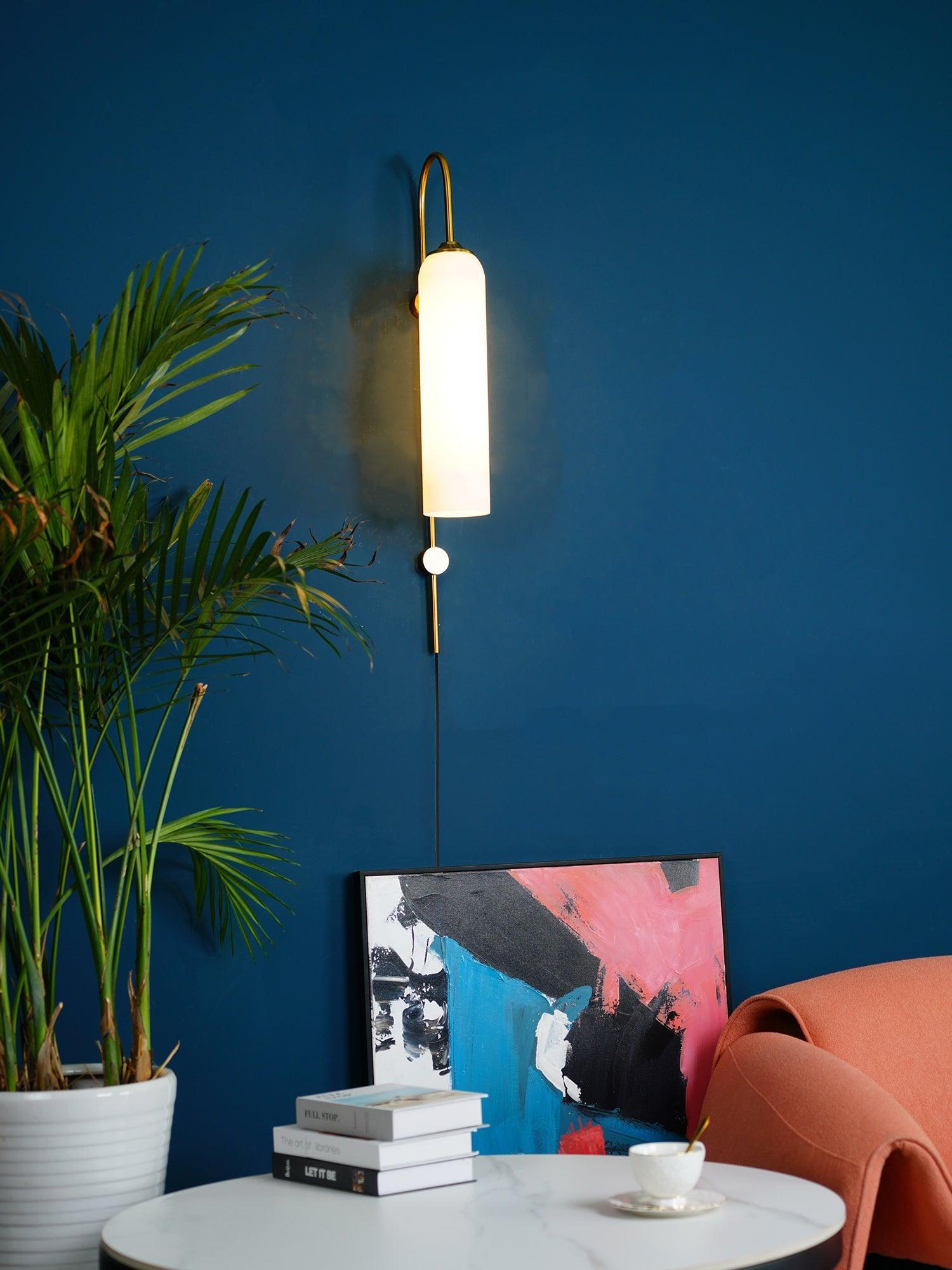 White glass wall lamp against a blue wall