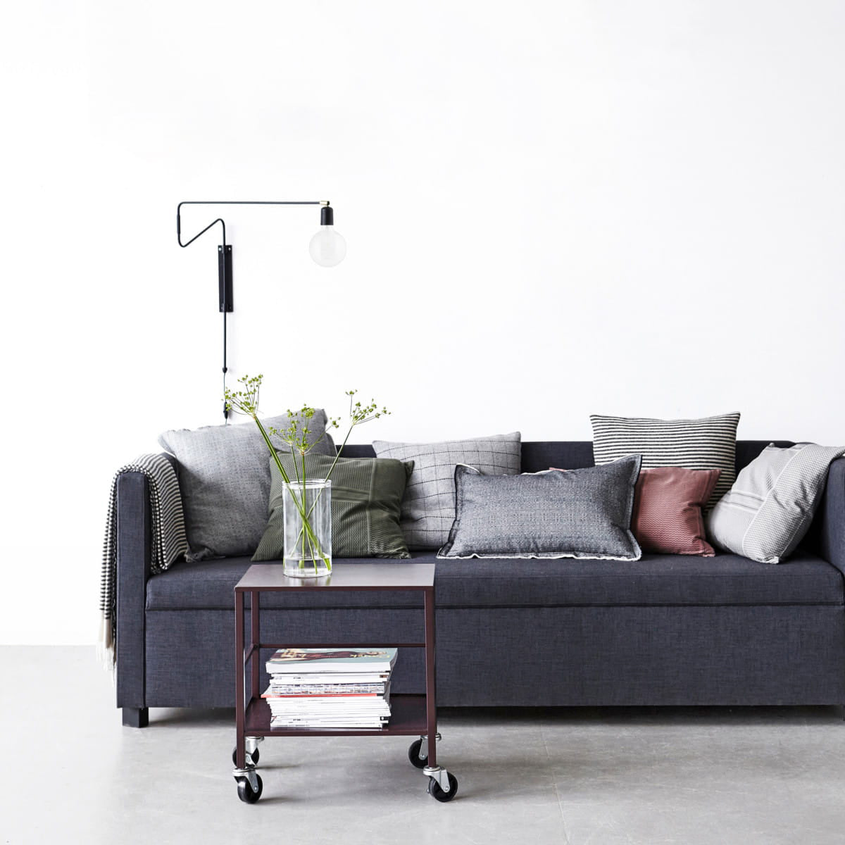 Black Swing wall light above a grey sofa