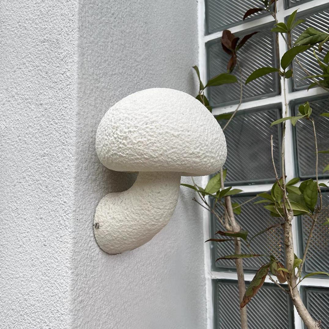 Mushroom wall lamp photographed beside wall plants