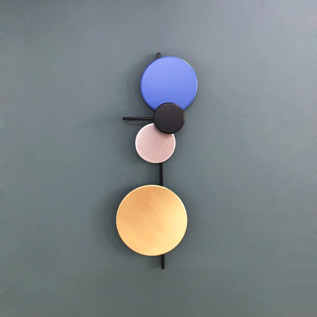 Blue disc wall lamp on a grey wall