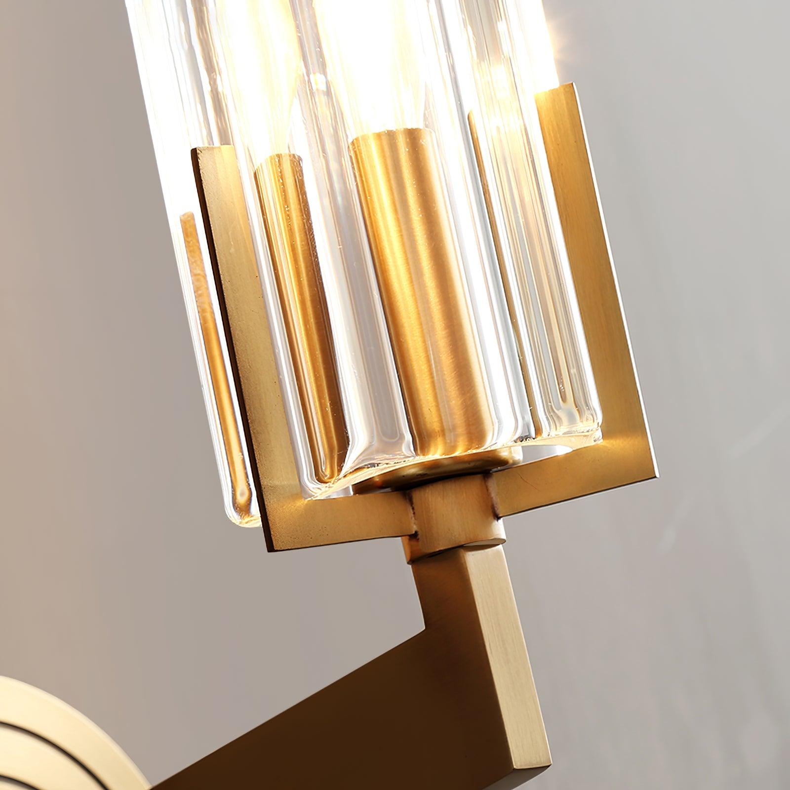 Extreme close lower glass flutes beside brass bulb sleeve and square support prongs above the rectangular arm