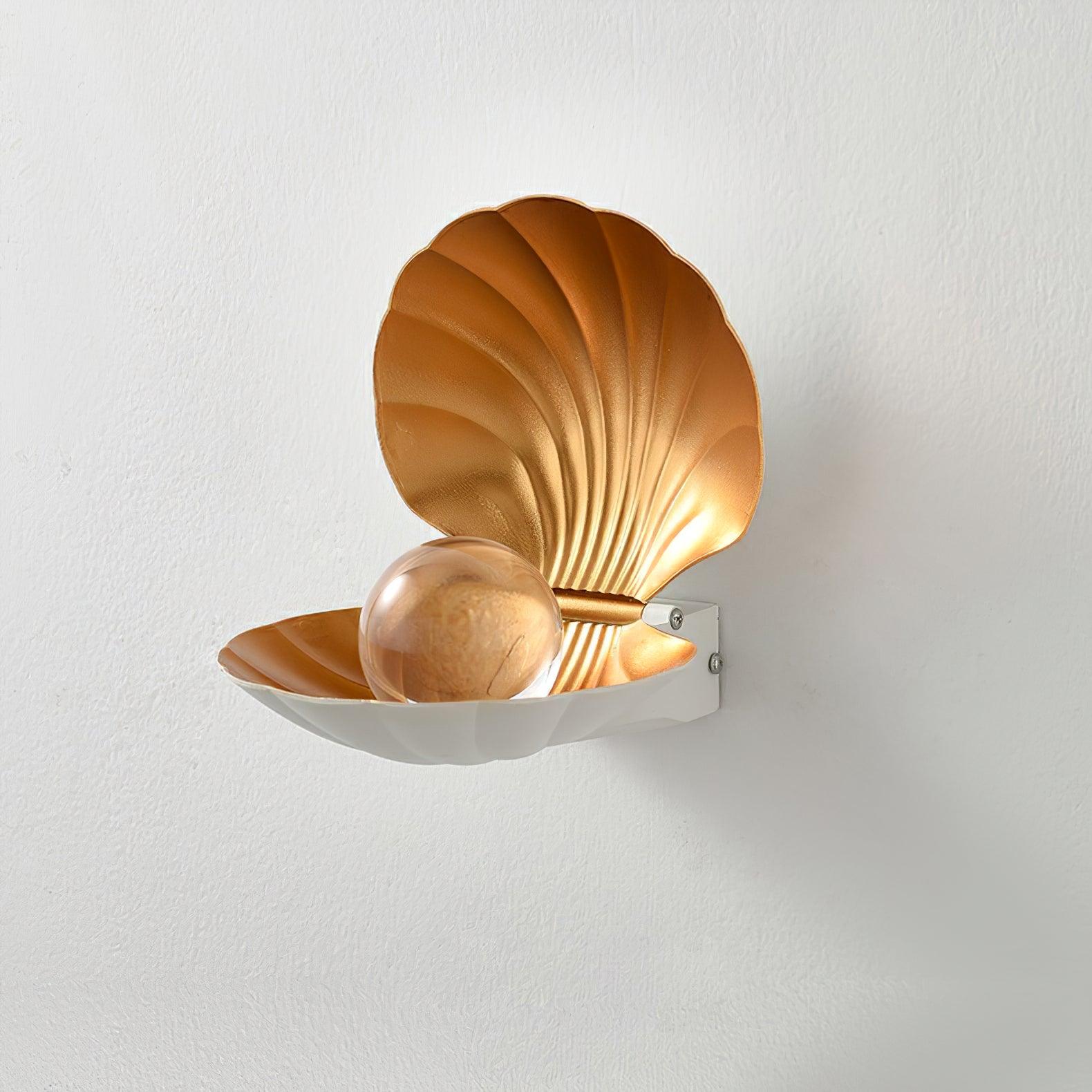 Unlit white clam-shaped wall light with a clear globe, gold-tone inner shell and visible mounting screws