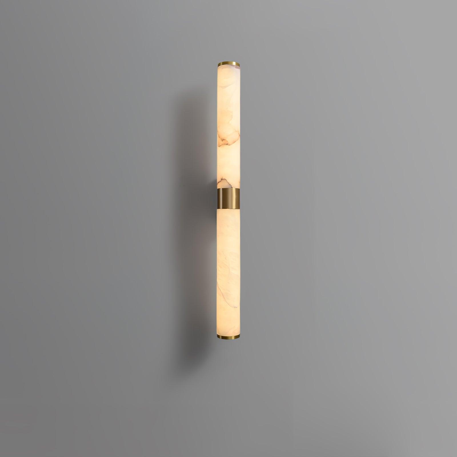 Slim alabaster tube casting light against a grey wall