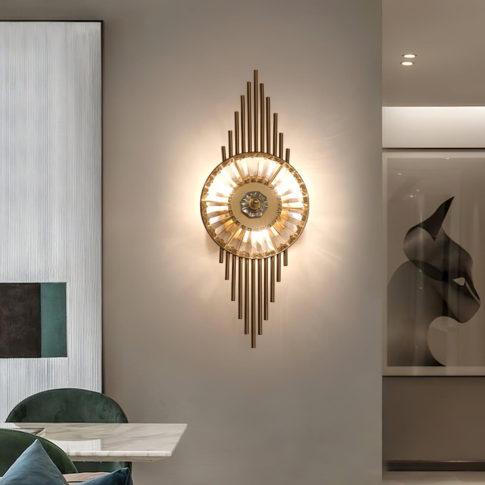 Illuminated gold and clear glass wall light beside a dining table, green chairs and a display niche