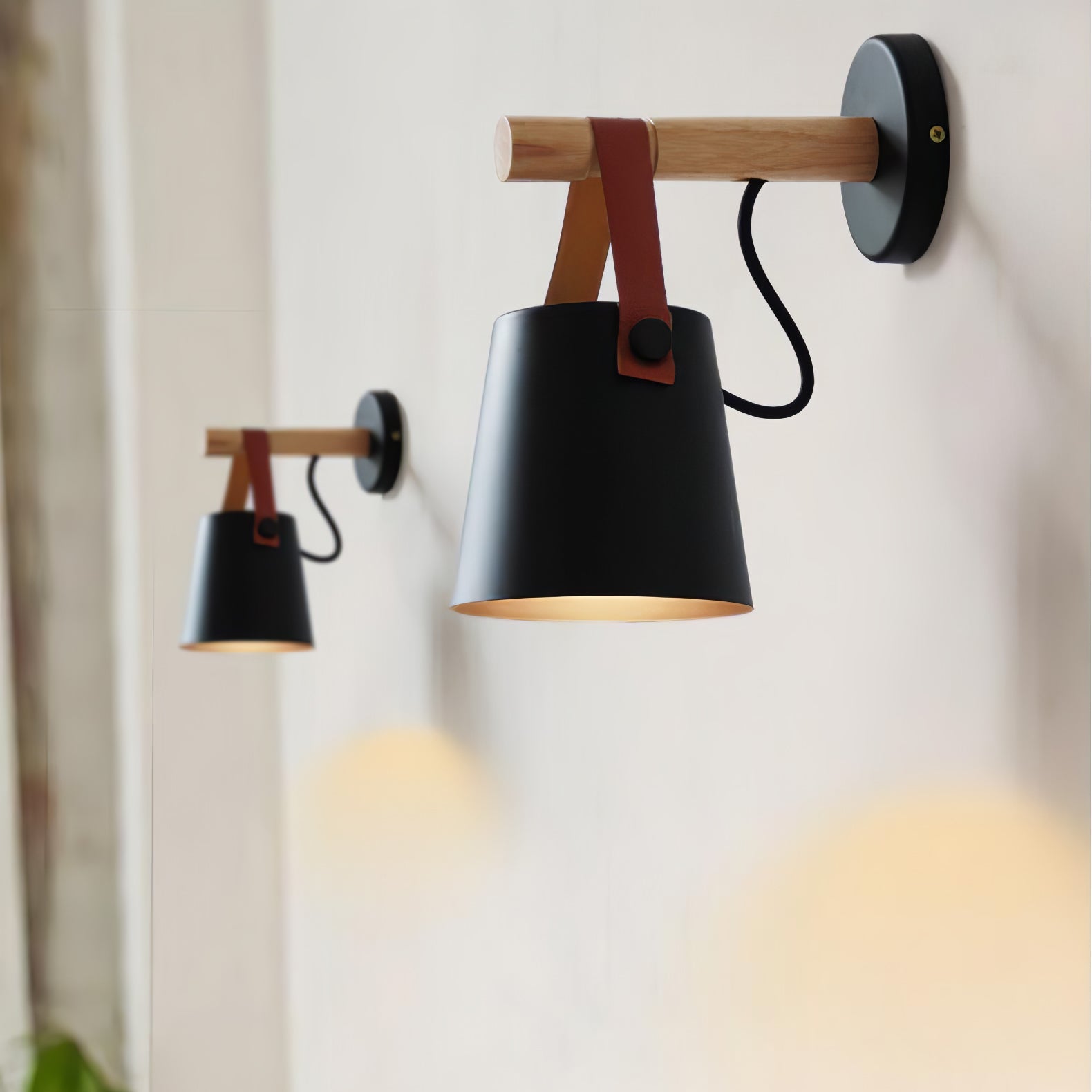 Pair of black conical wall lights on a pale wall