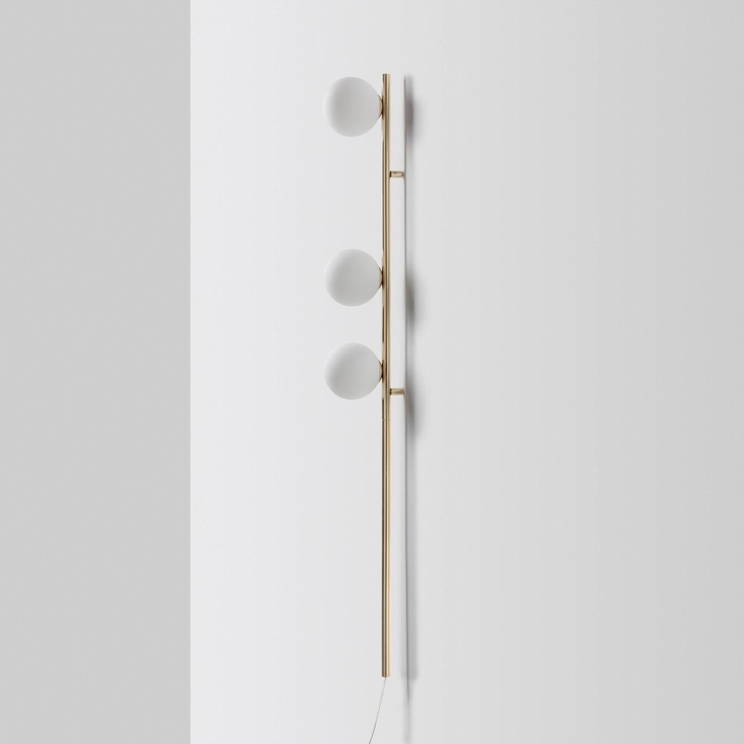 Side view of Gold Candied Balls wall light, three white globes, two short wall brackets and pale lower cord