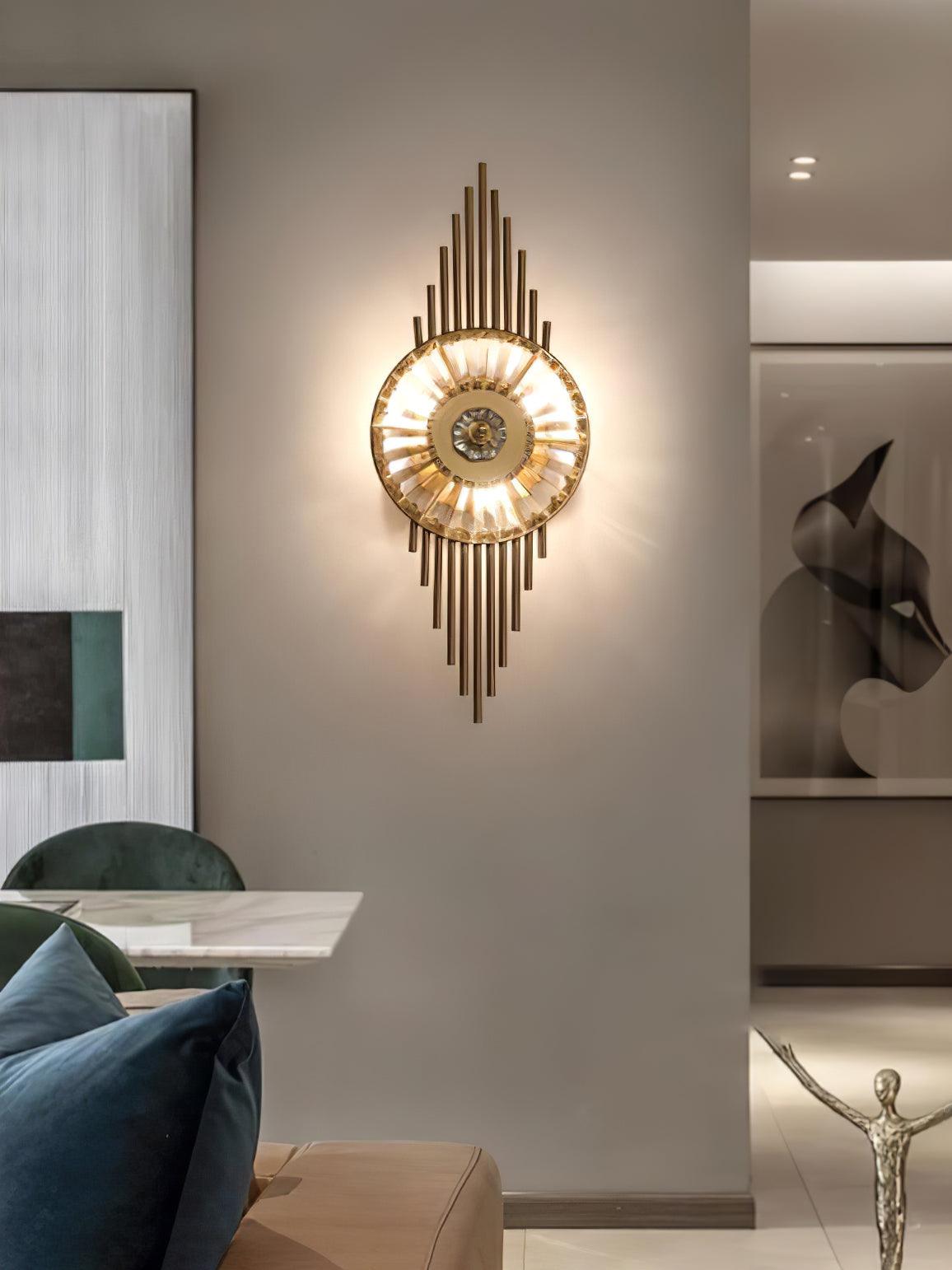 Gold rod wall light glowing on a pillar beside green dining chairs, blue cushions and a sculpture